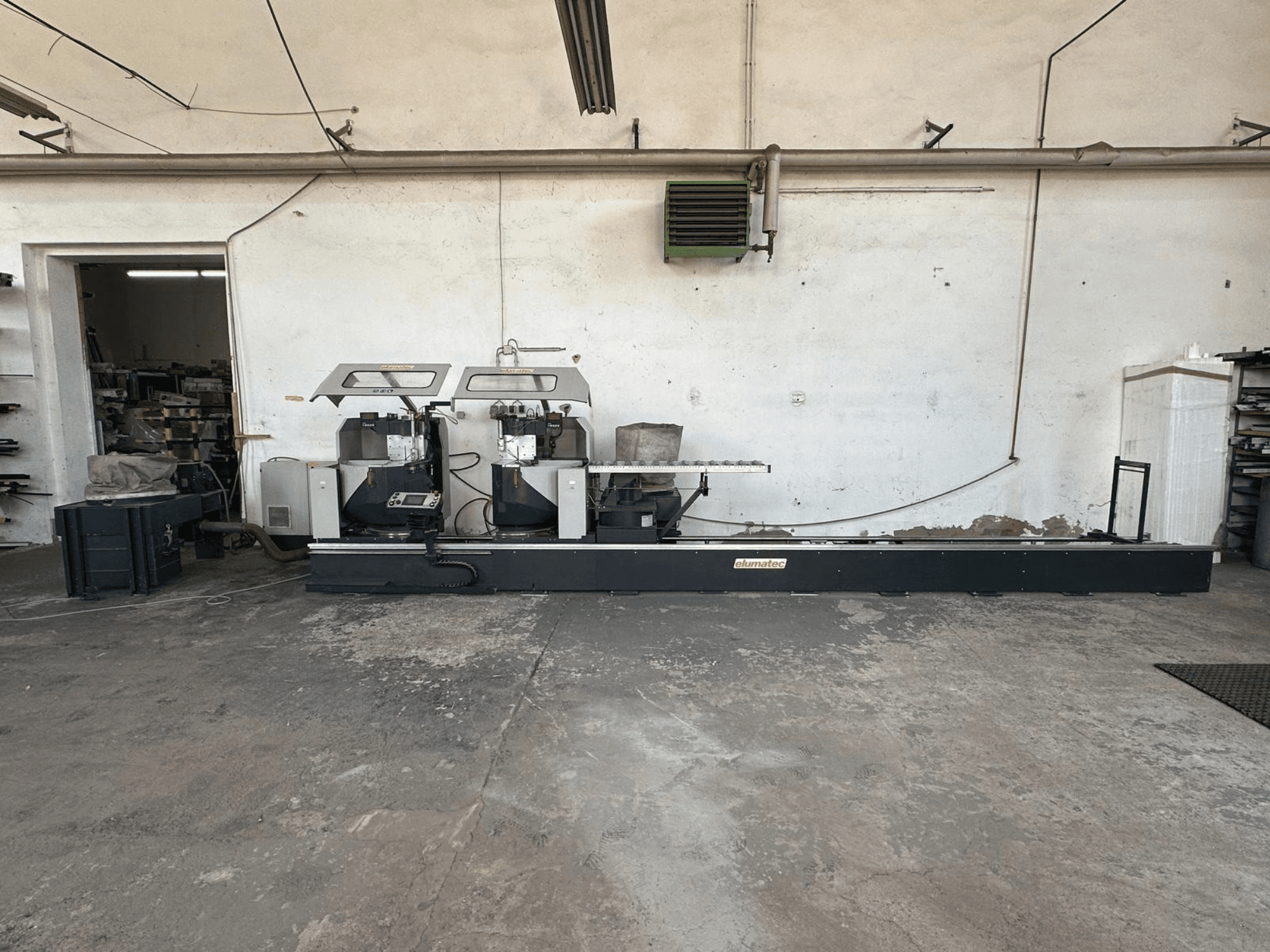 Elumatec DG 244 metallist ketassaag töökojas, külgvaates on näha kahte saagi ja juhtimisseadmeid tugeval alusel.