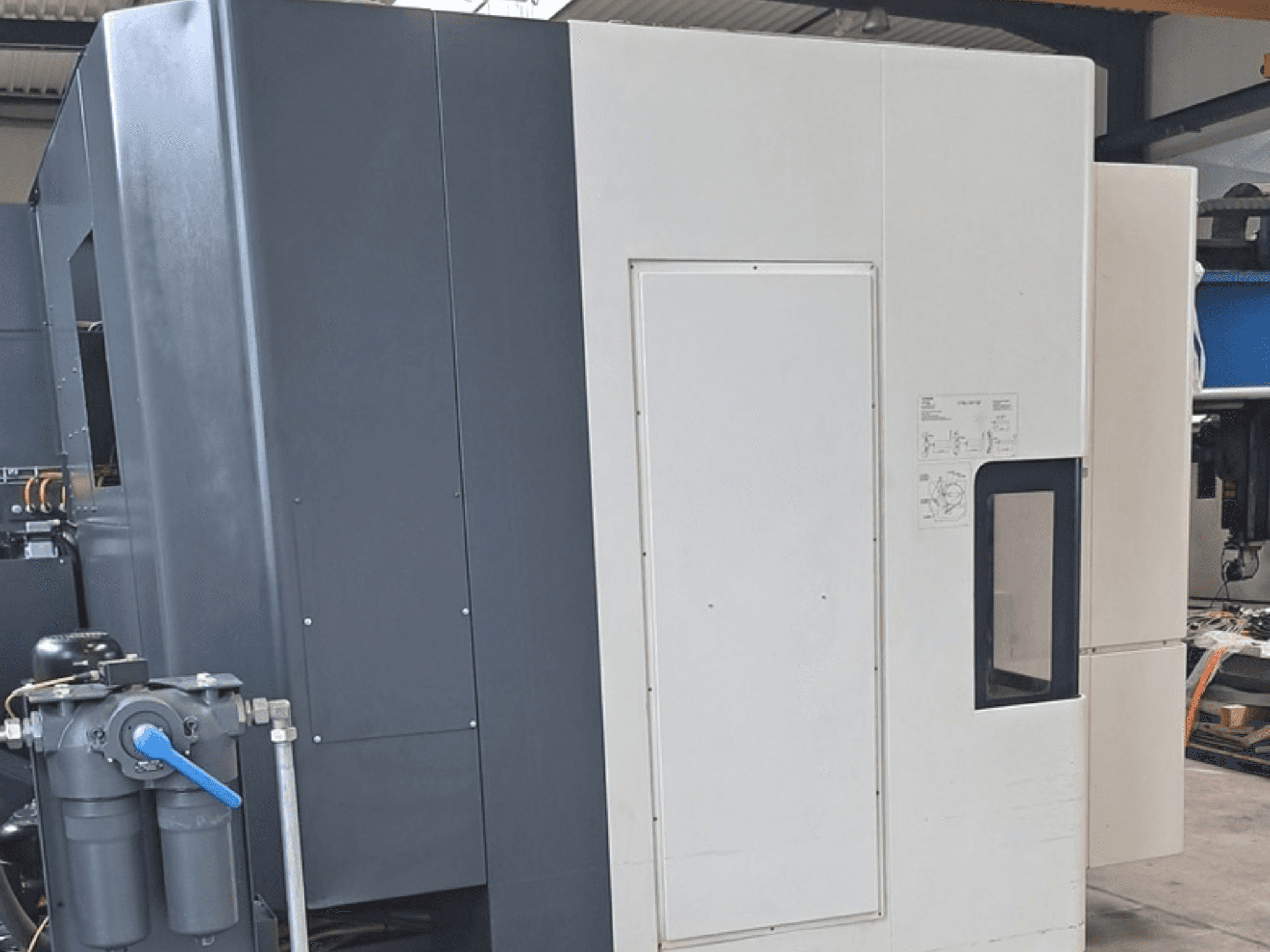 DMG MORI NHX5000 horisontaalne töötlemiskeskus, külgvaade, millel on näha juhtpaneel ja mehaanilised osad.