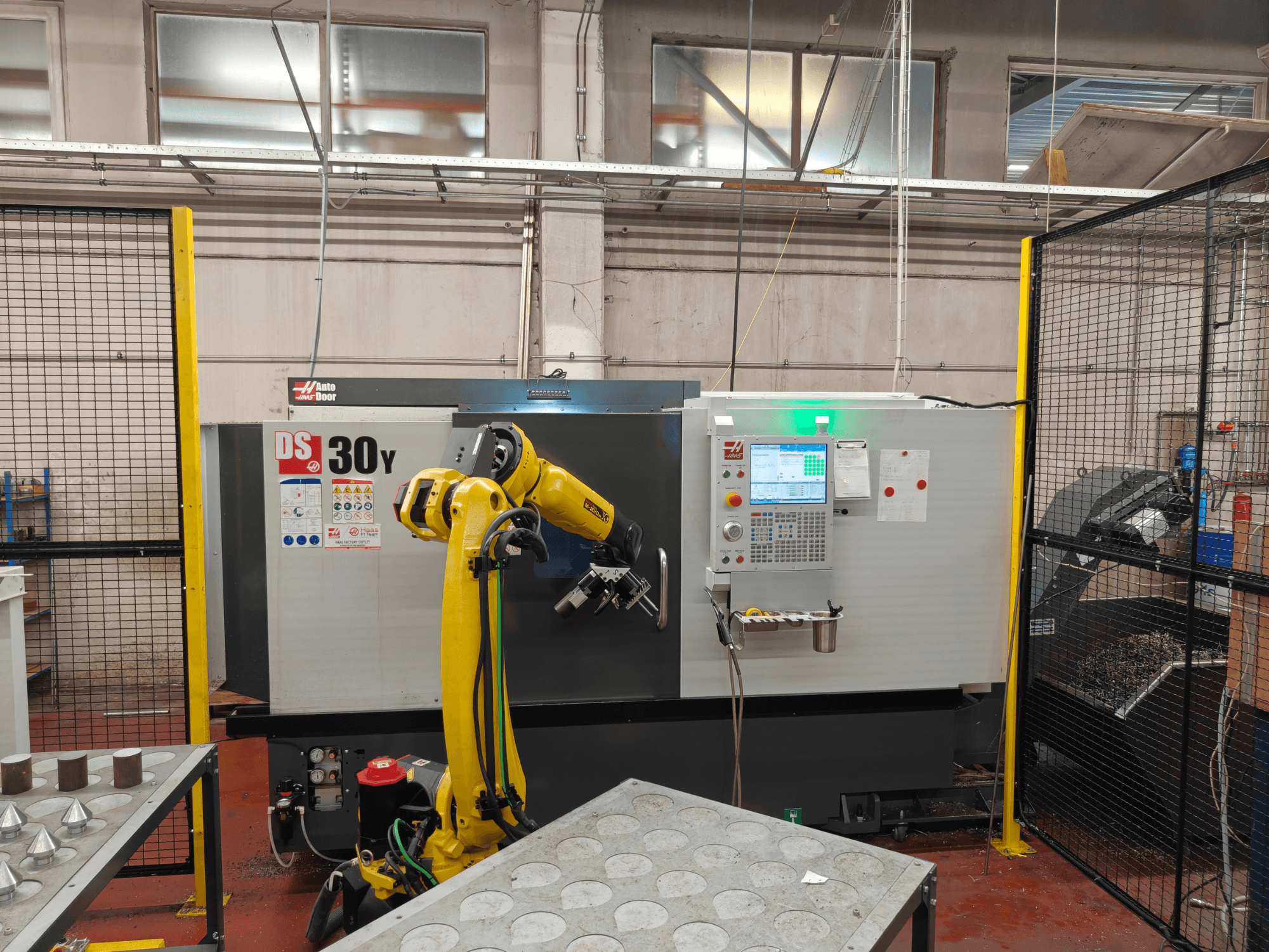 HAAS DS30Y horisontaalne treipink koos robotkäega, vaade eest, millel on näha juhtpaneel ja töötsoon.