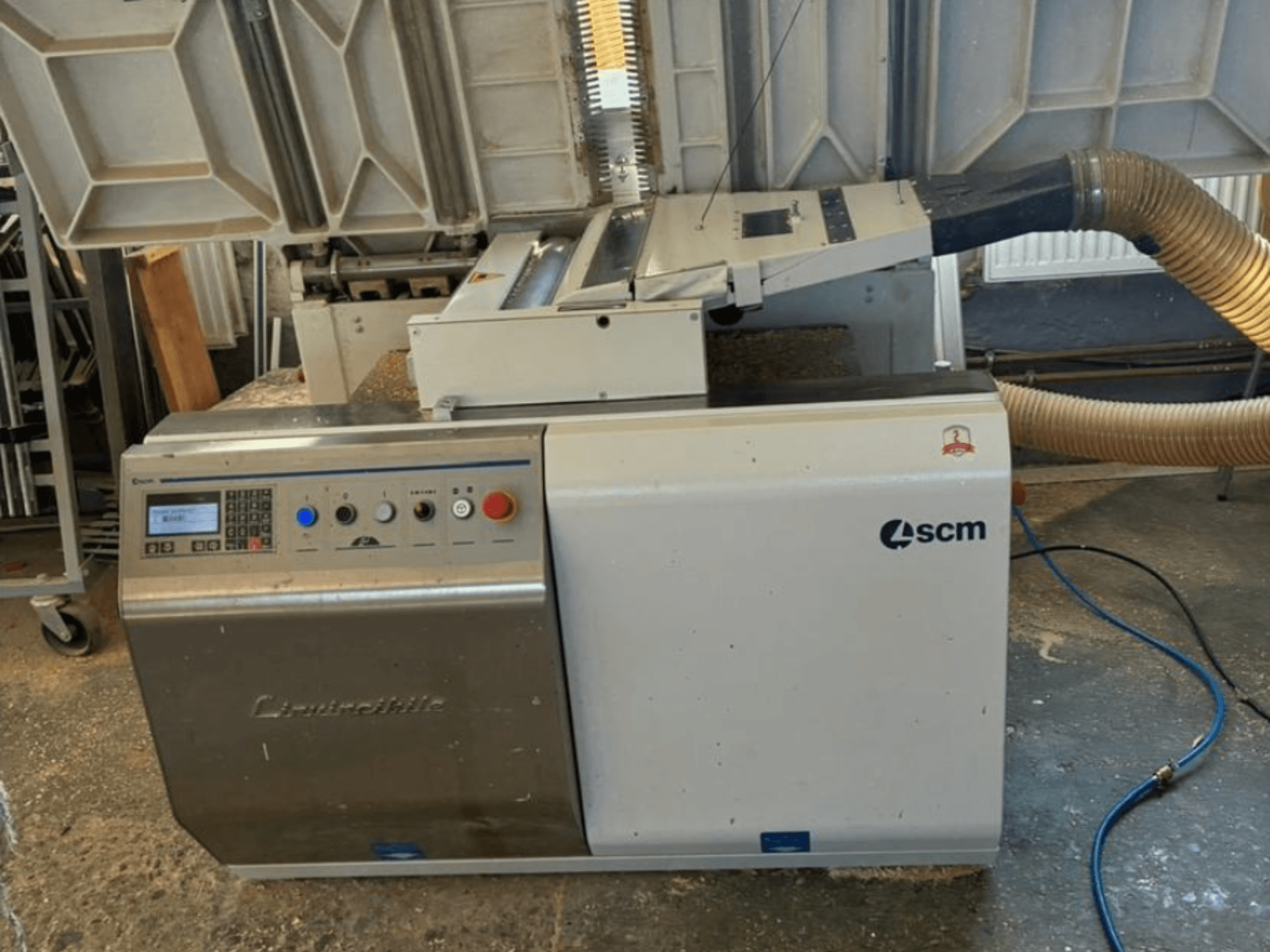 SCM Centauro servapaigaldusmasin esiplaanil, kus on näidatud juhtpaneel, imemisvoolik ja avatud tööala serva pealekandmiseks.