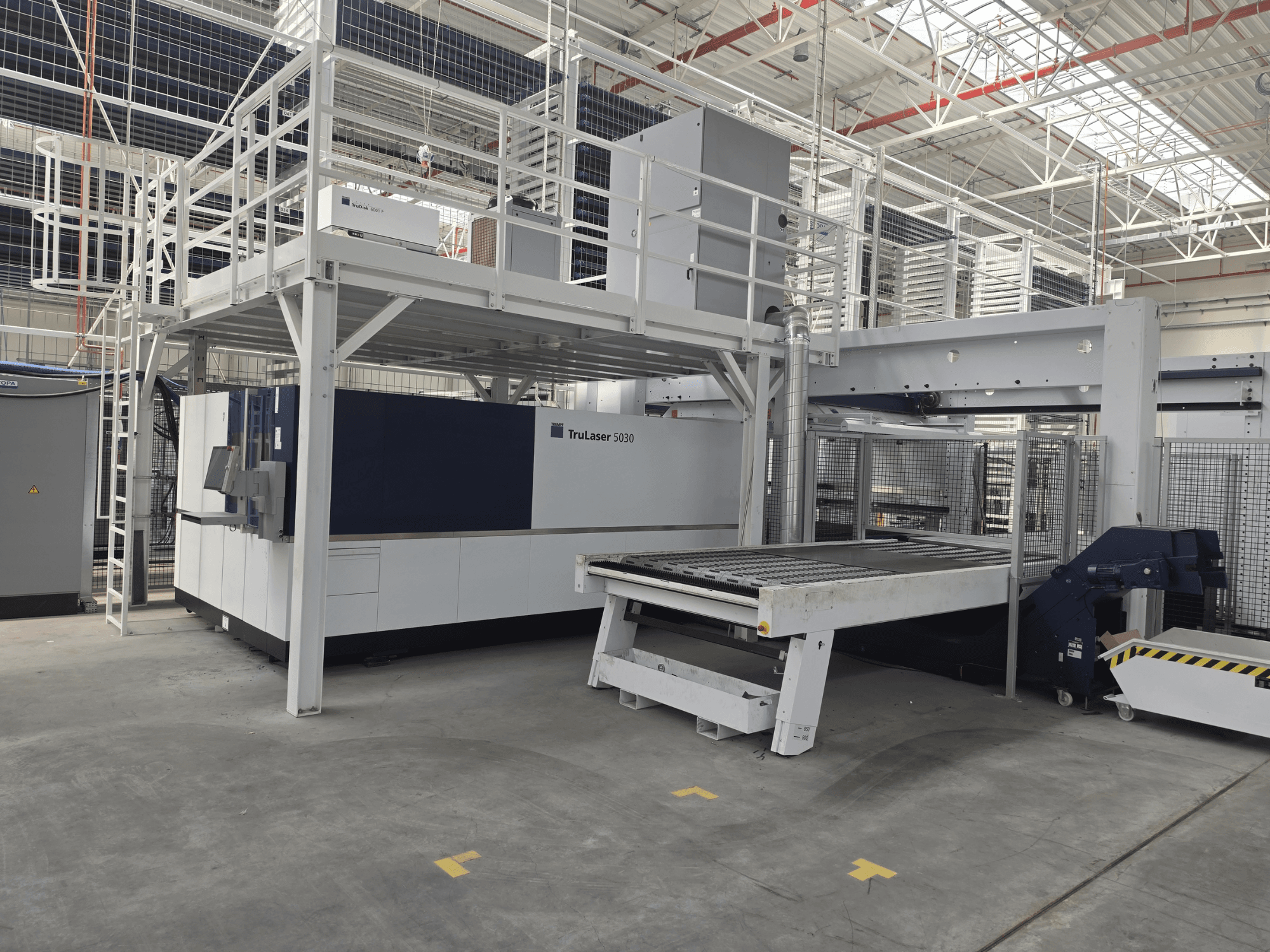 TRUMPF TruLaser 5030 fiber L76 FMC-seade töökodas, esivaade, millel on näha lõikepind ja laadimis-/mahalaadimismehhanism.