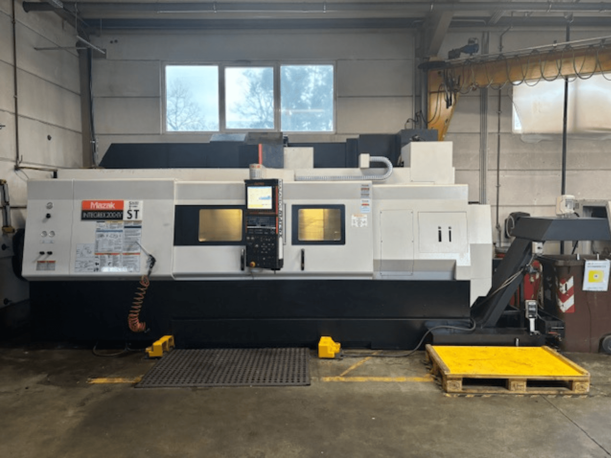 Mazak Integrex 200 SY ST, külgvaade, kus on näidatud juhtpaneel, töönäidikud ja jahutusvedeliku liinid töökojas.