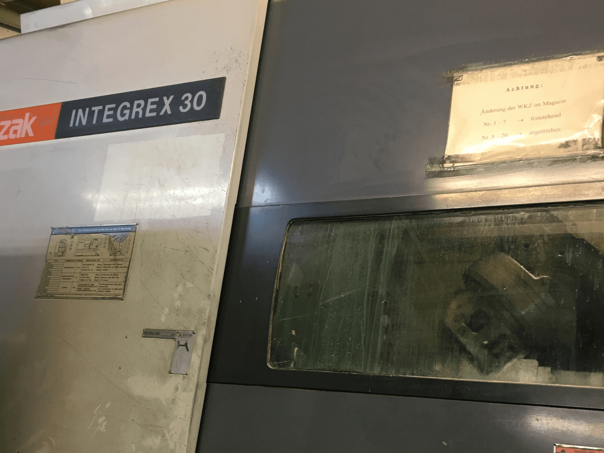 Mazak Integrex 30 Y Universal 1000 treimis- ja freesimiskeskuse vaade eest, millel on näha juhtimispaneel ja akna taga asuvad tööriistad.