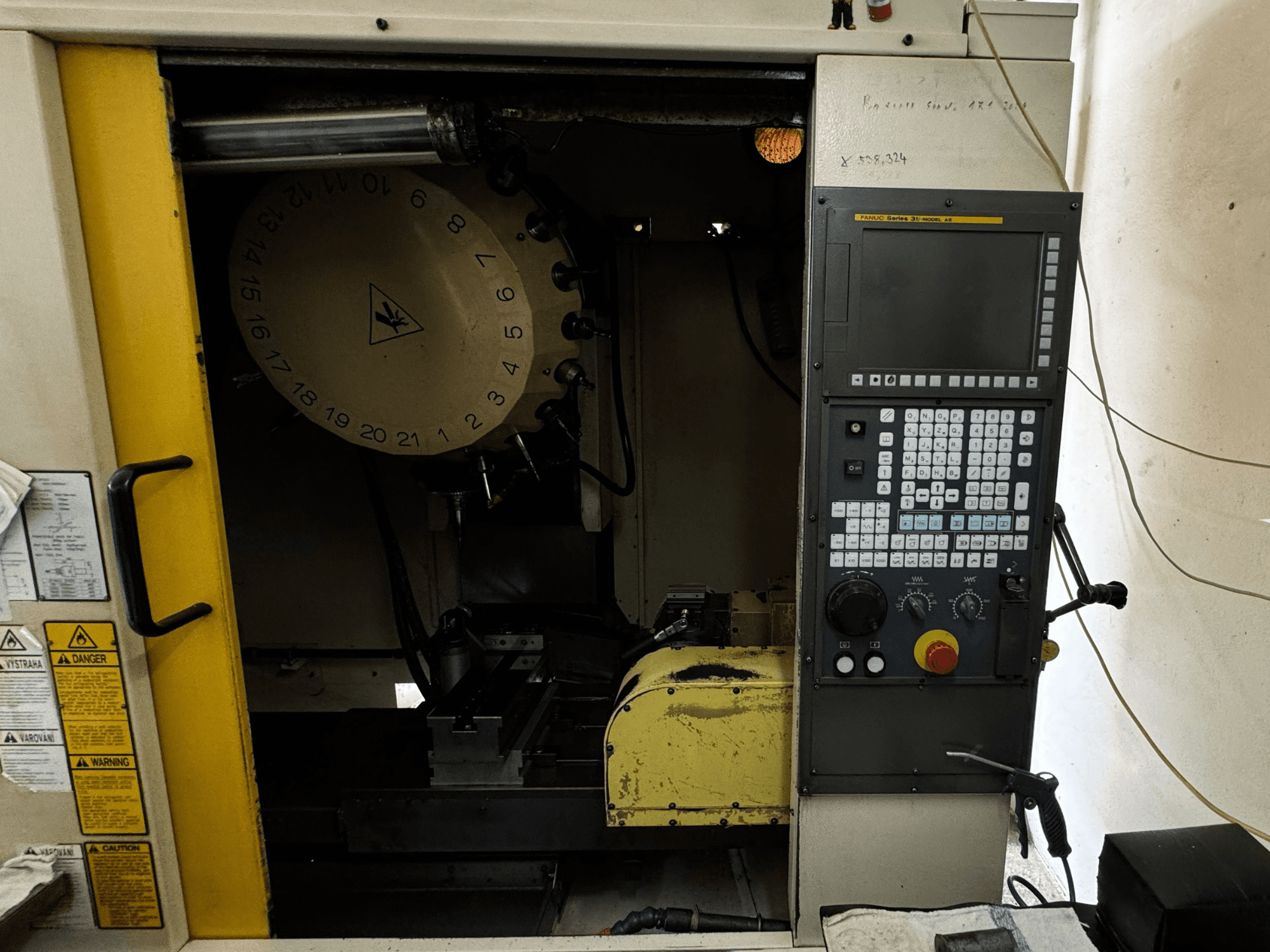 FANUC Robodrill alpha-T21iFL vertikaalne töötluskeskus, esiplaanil on juhtpaneel ja tööriistade hoidik.