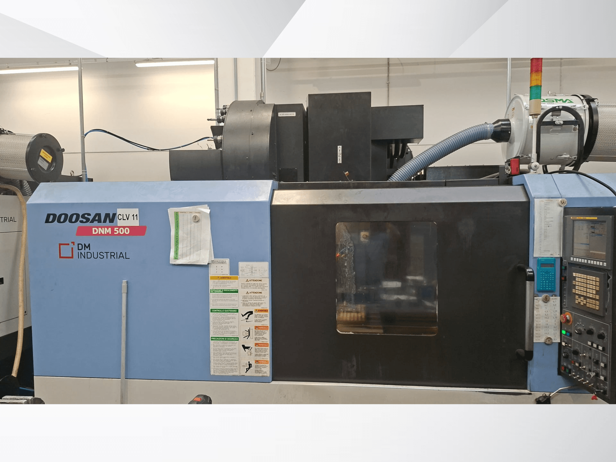 DOOSAN DNM 500 vertikaalne töötlemiskeskus külgvaates, millel on näha juhtpaneel ja töötavad osad.