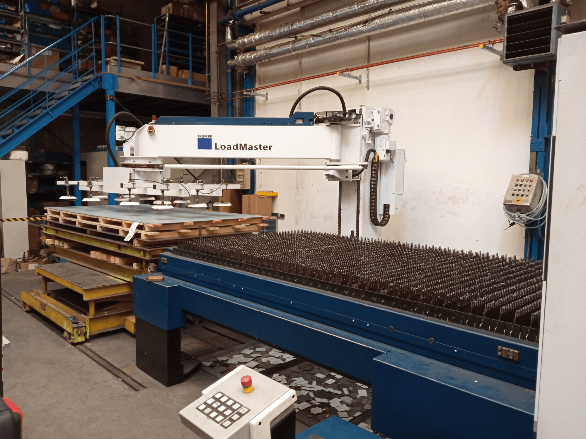 TRUMPF TruLaser 3030 CO₂-laserlõikemasin külgvaates, millel on LoadMaster ja materjalipalettid.