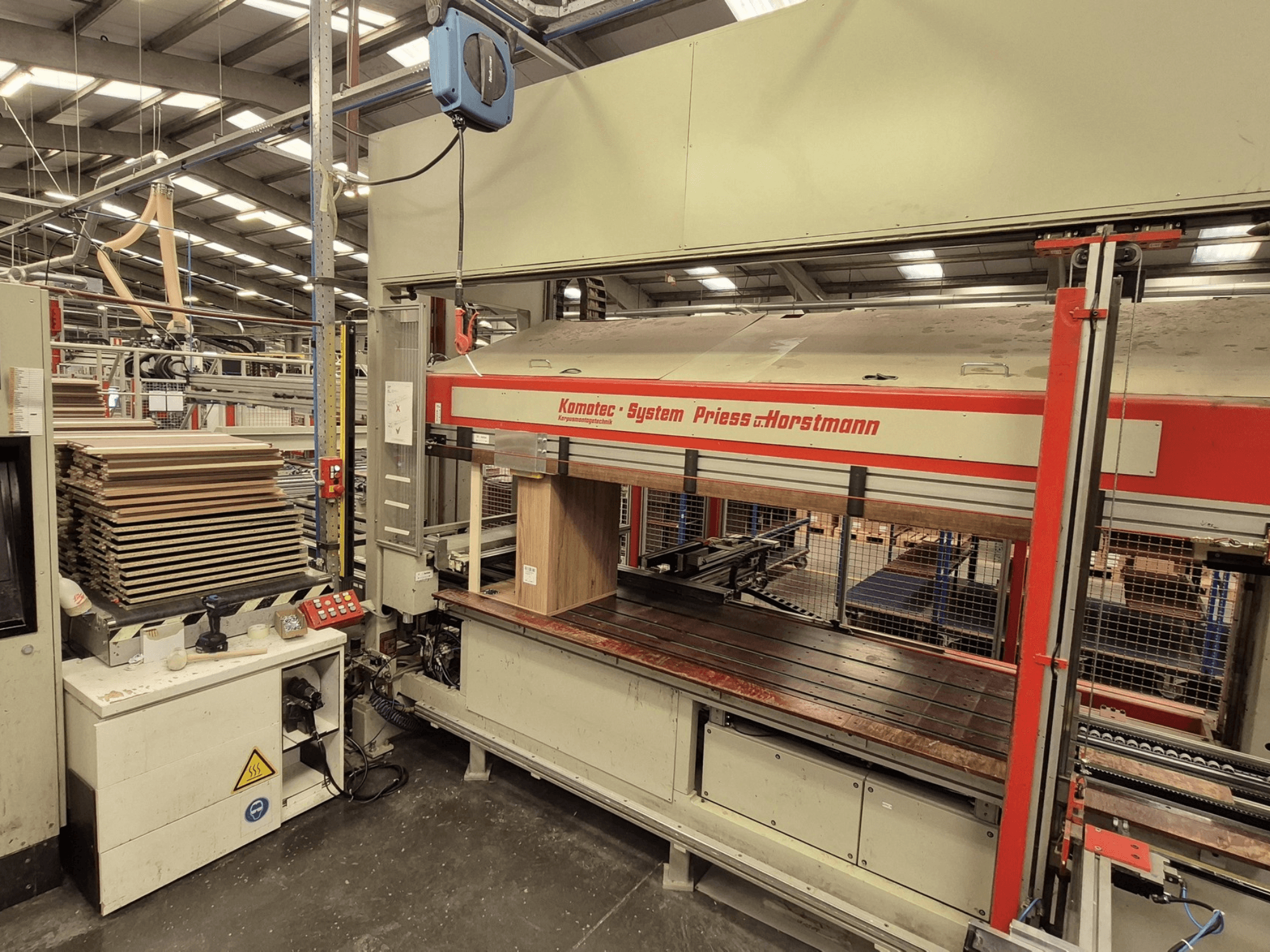 PREISS U HORTSTMANNi spoonipress KP-5-CNC, esiplaanil, kus on näha virnastatud spoonilehed ja juhtpaneel.