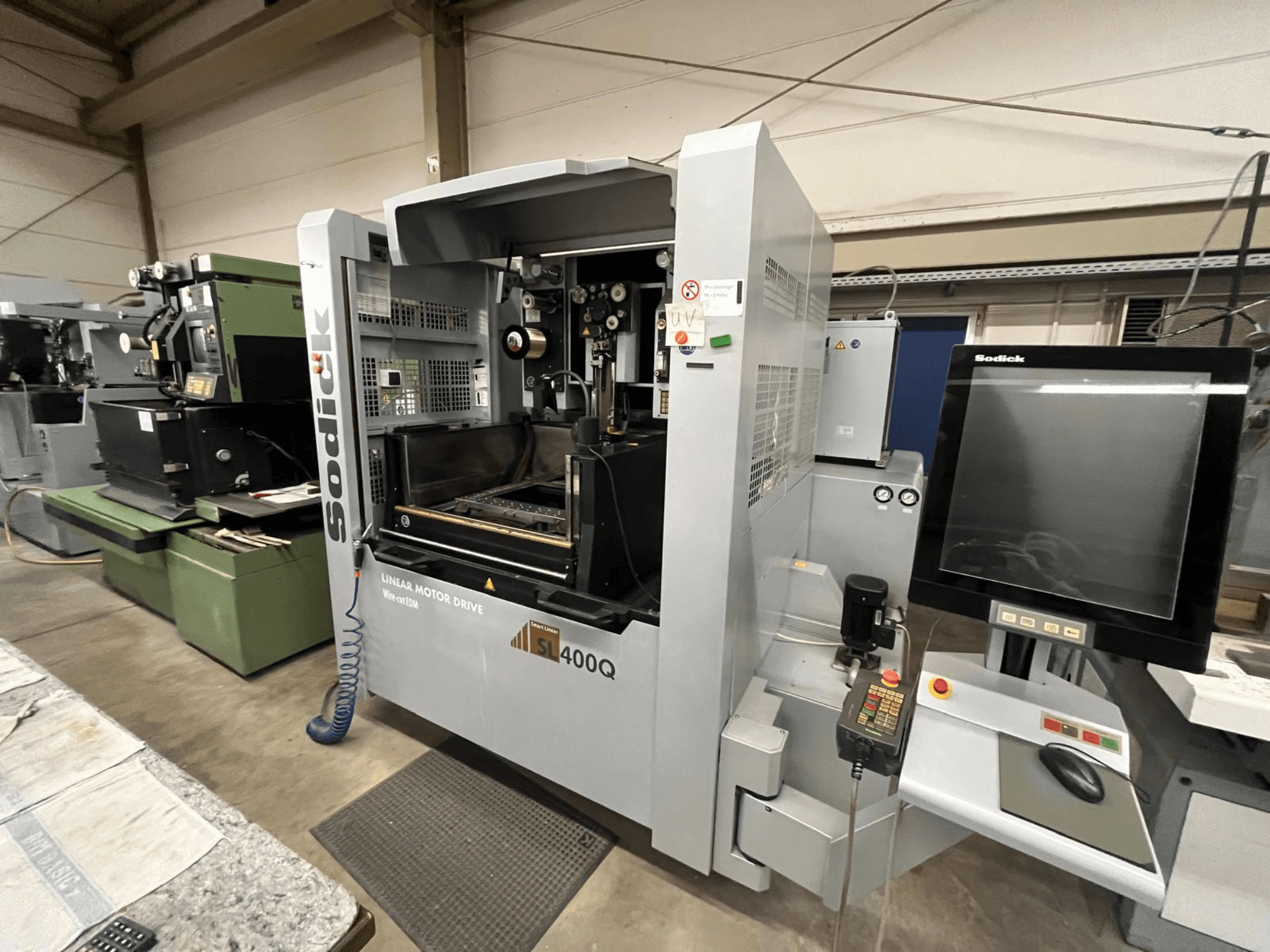 Sodick SL400Q lineaarmootoriga CNC-tööpink, esivaade digitaalse juhtpaneeli ja ekraaniga töökojas.