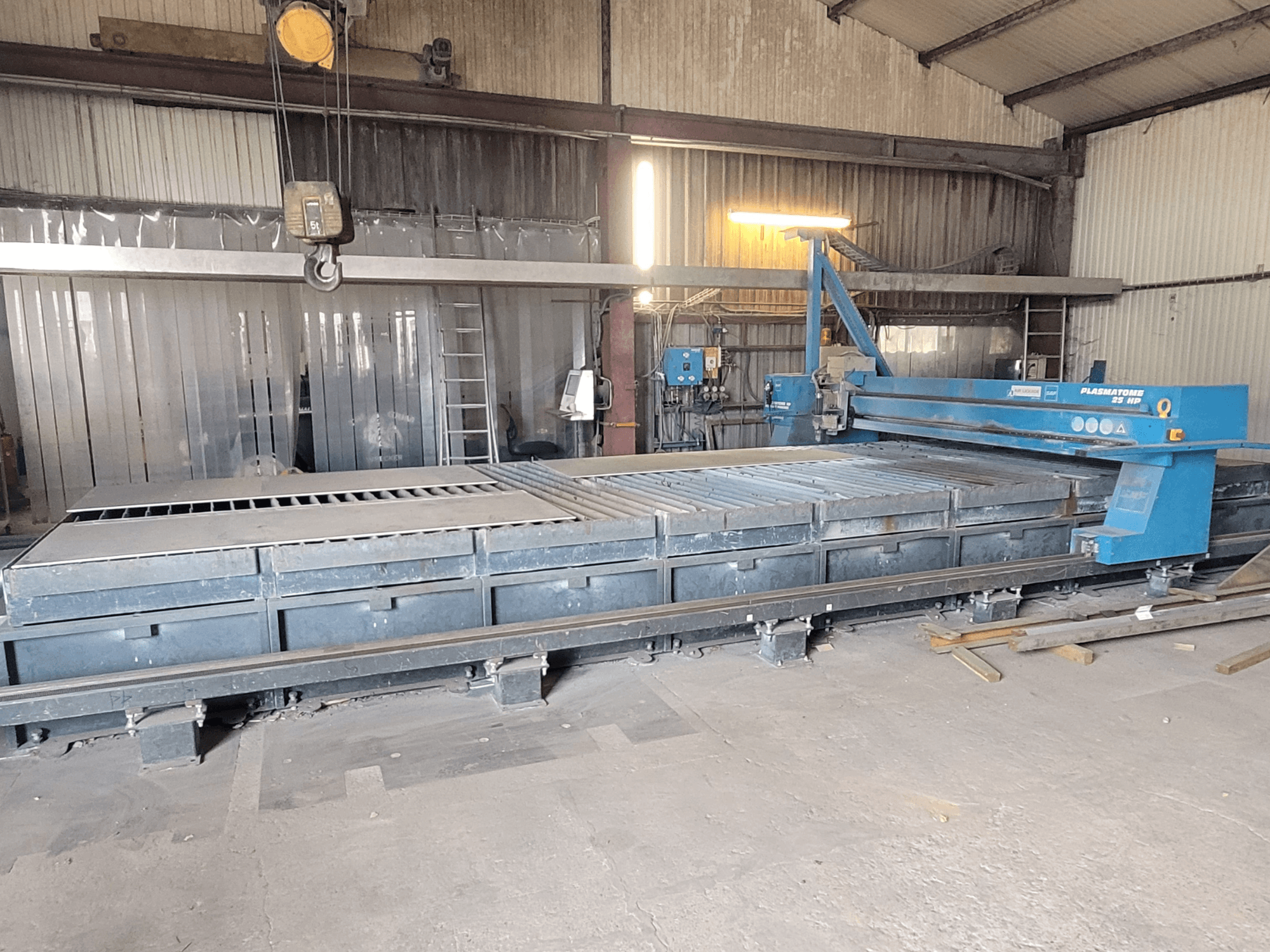 SAF Plasmatone 25Hp plasmalõikusmasin, külgvaade, kus on näha lõikeplaat ja töökomponendid tööstuslikus keskkonnas.