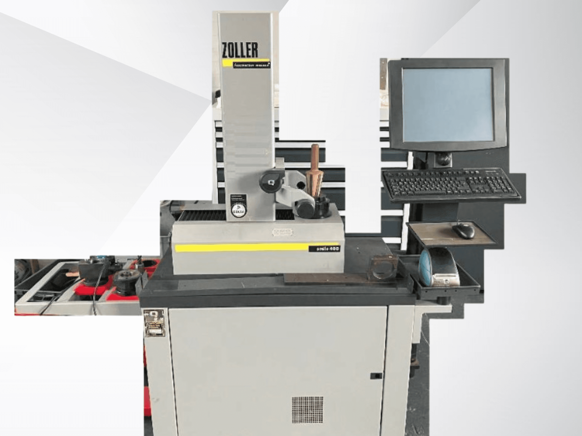 ZOLLERi mõõtmismasin koos arvutimonitori, klaviatuuri ja tööriistadega; esiplaanil on näha halli värvi ja moodsat disaini.
