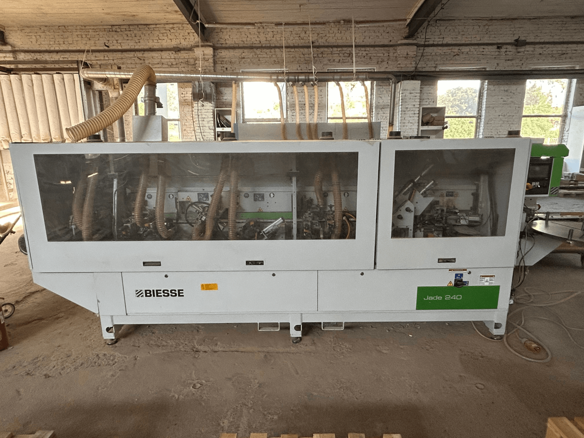 BIESSE Jade 240 servakleebimismasin valge ja rohelise värviga, vaade eest, millel on näha juhtpaneel ja masina sisemuse detailid.
