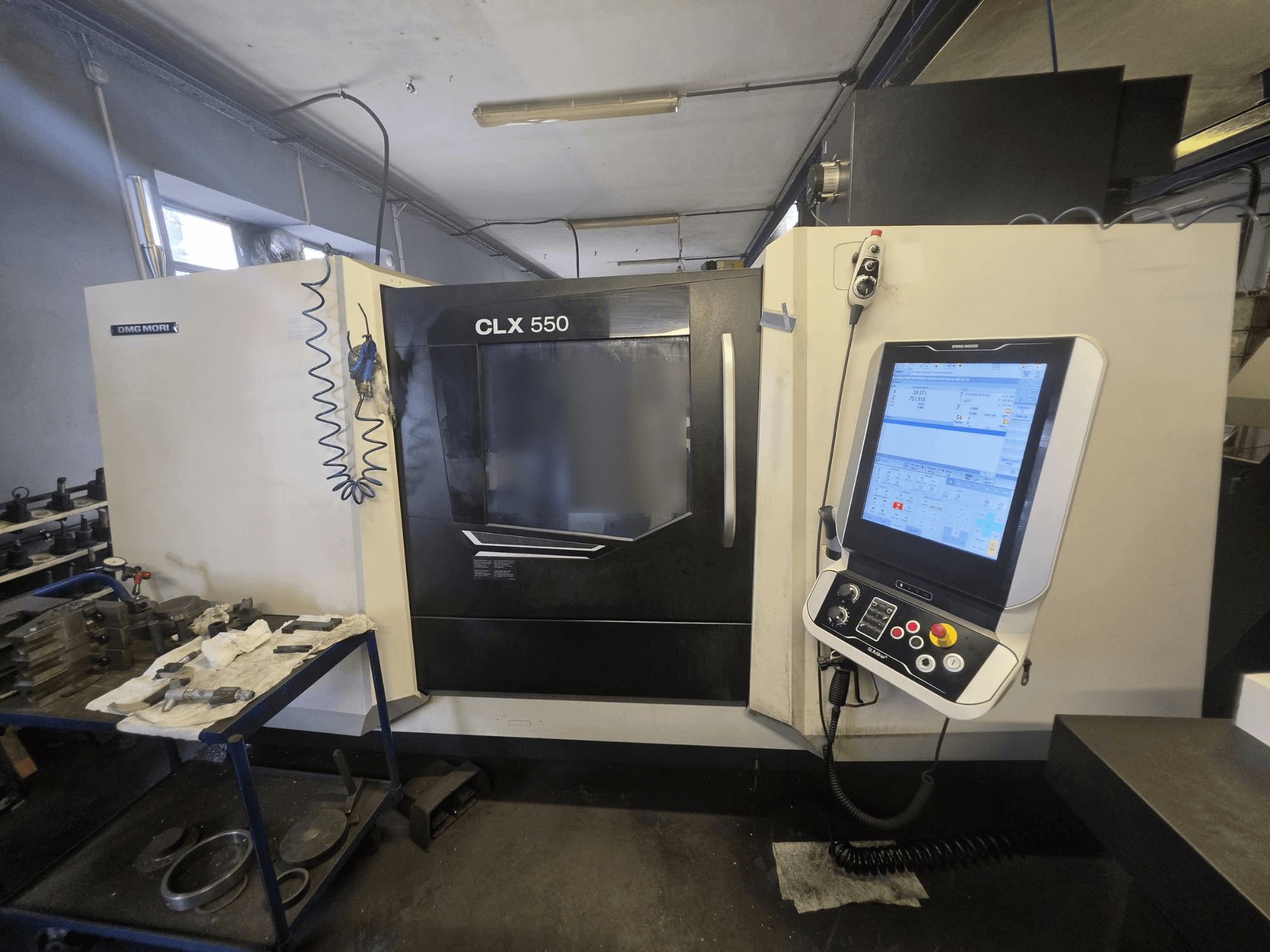 DMG MORI CLX 550 V3 horisontaalne treipink, vaade eest, millel on näha juhtpaneel ja tööala koos tööriistadega.