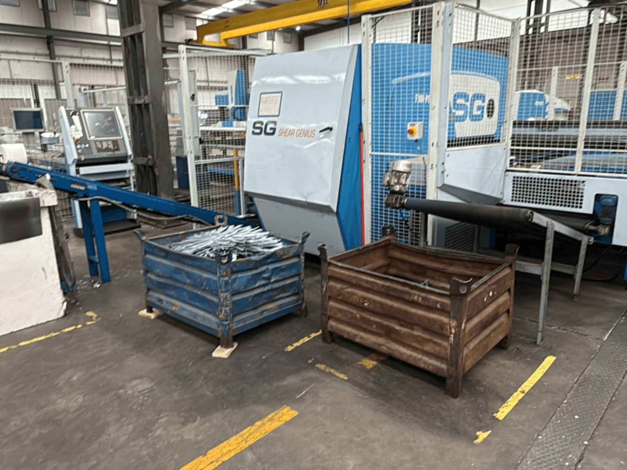Finn-Power SG6 12.61 stantsimis- ja painutusmasin, esiplaanil, kõrval metallkonteinerid töökojas.