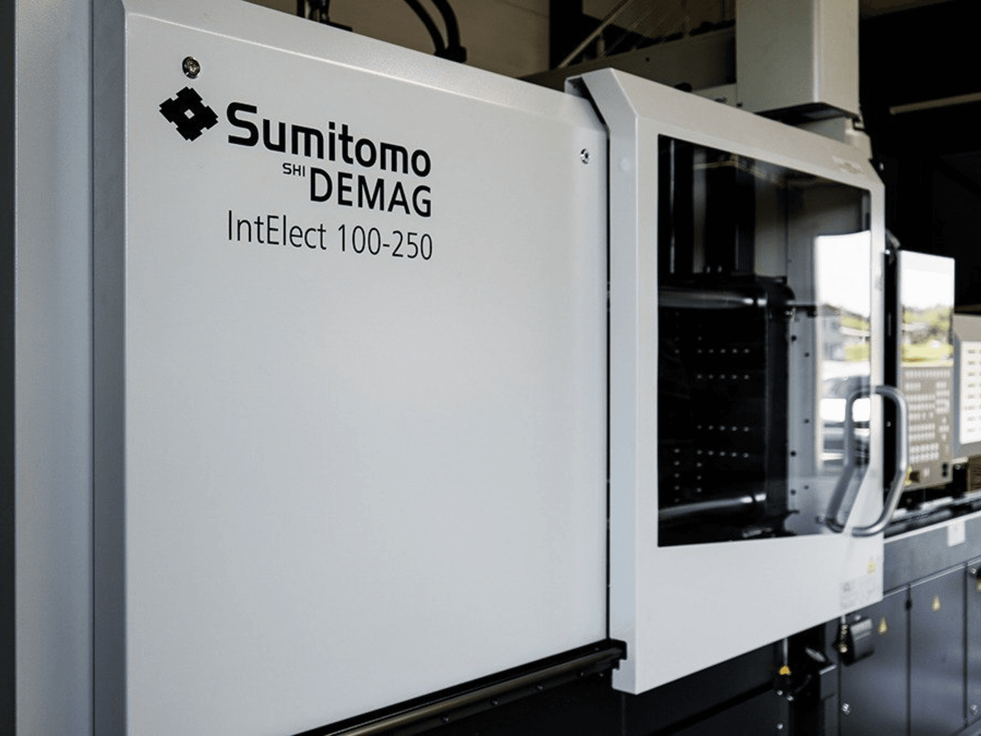 SUMITOMO SHI DEMAG IntElect 100/250 elektrilise süstimisvormimismasina esivaade koos juhtpaneeli ja ohutusseadmetega.