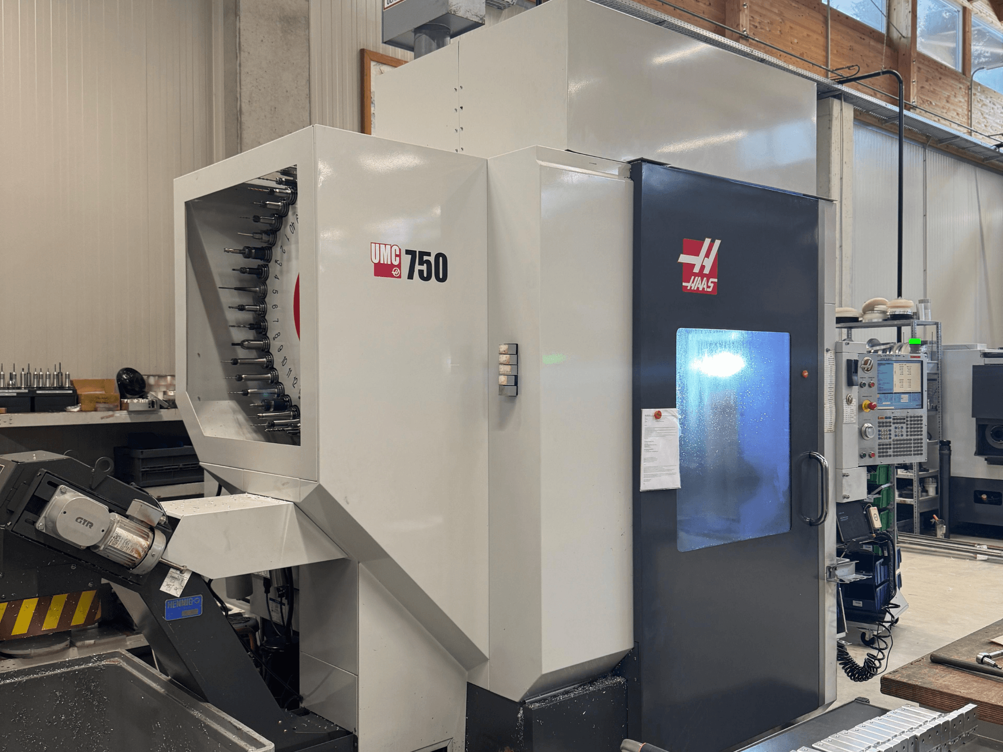Haas UMC 750 töötluskeskuse esiplaan, kus on näha tööriistahoidja ja juhtpaneel töökojas.