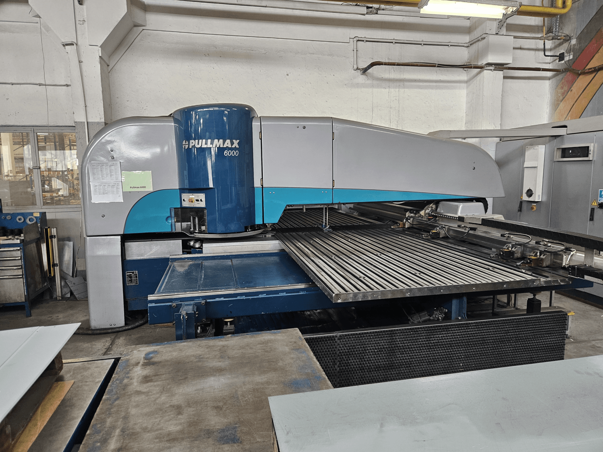 Pullmax 6000 CNC-stantsimispingi esivaade, mis näitab selle suurt lamealust ja metallraamistikku töökojas.
