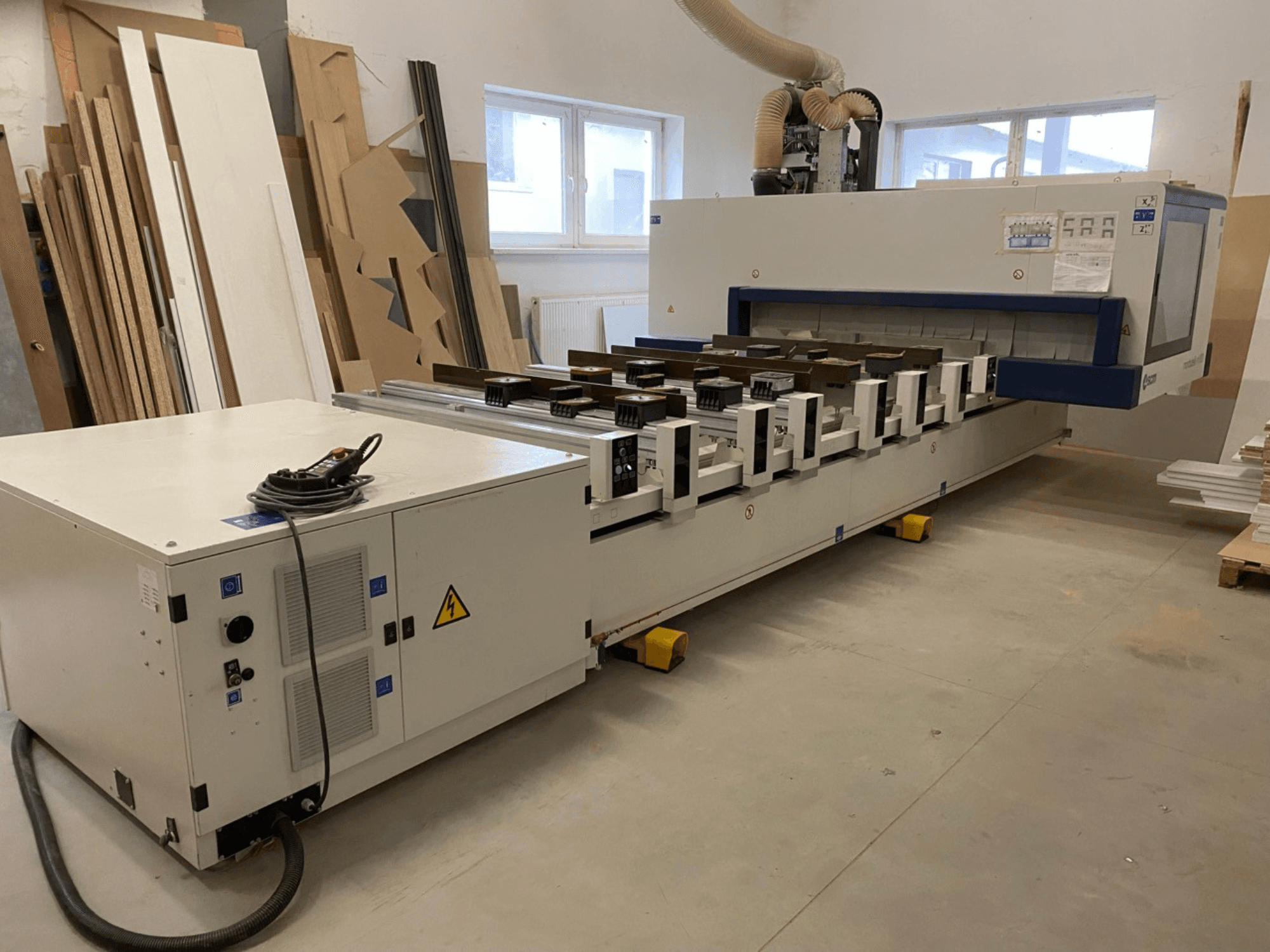 SCM Morbidelli toodetud M100 CNC-puidu töötlemiskeskus töökodas, pildil on näha esivaade koos juhtpaneeli ja tolmuimejaga.
