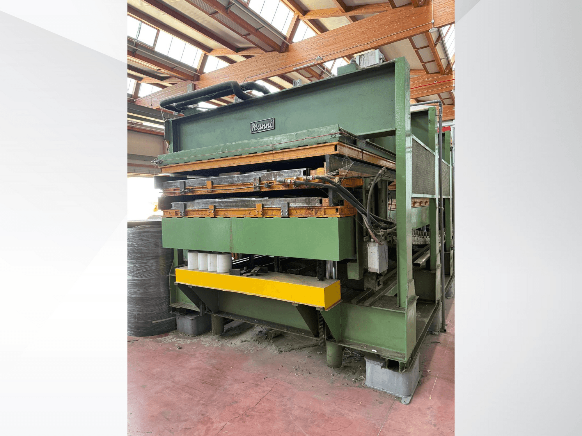 Manni hüdrauliline press, külgvaade, millel on roheline metallkere, kollane alus ja mitu nähtavat hüdraulilist joont.