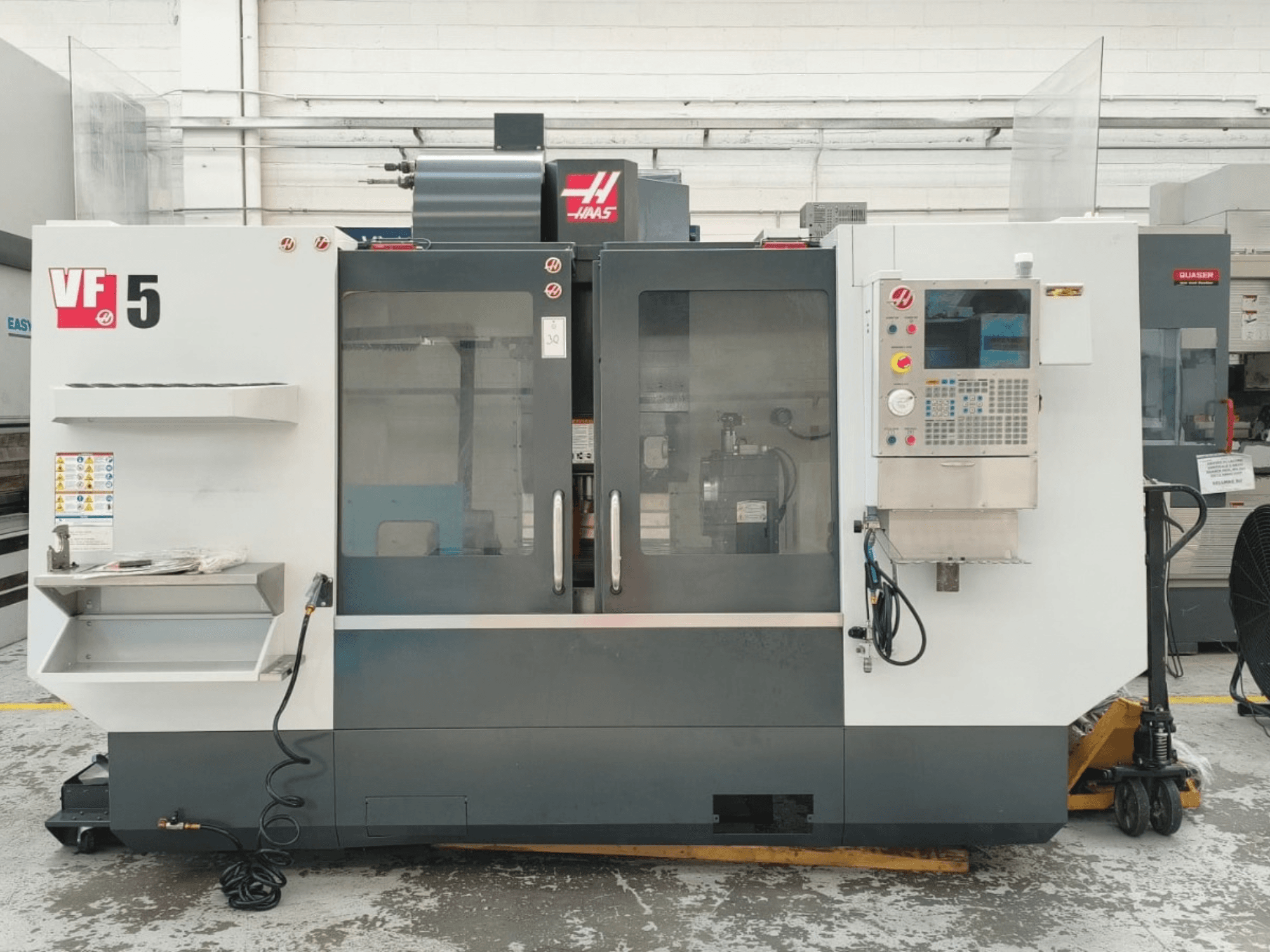 HAAS VF 5/40 vertikaalse töötlemiskeskuse vaade eest, millel on juhtpaneel ja klaasuksed.