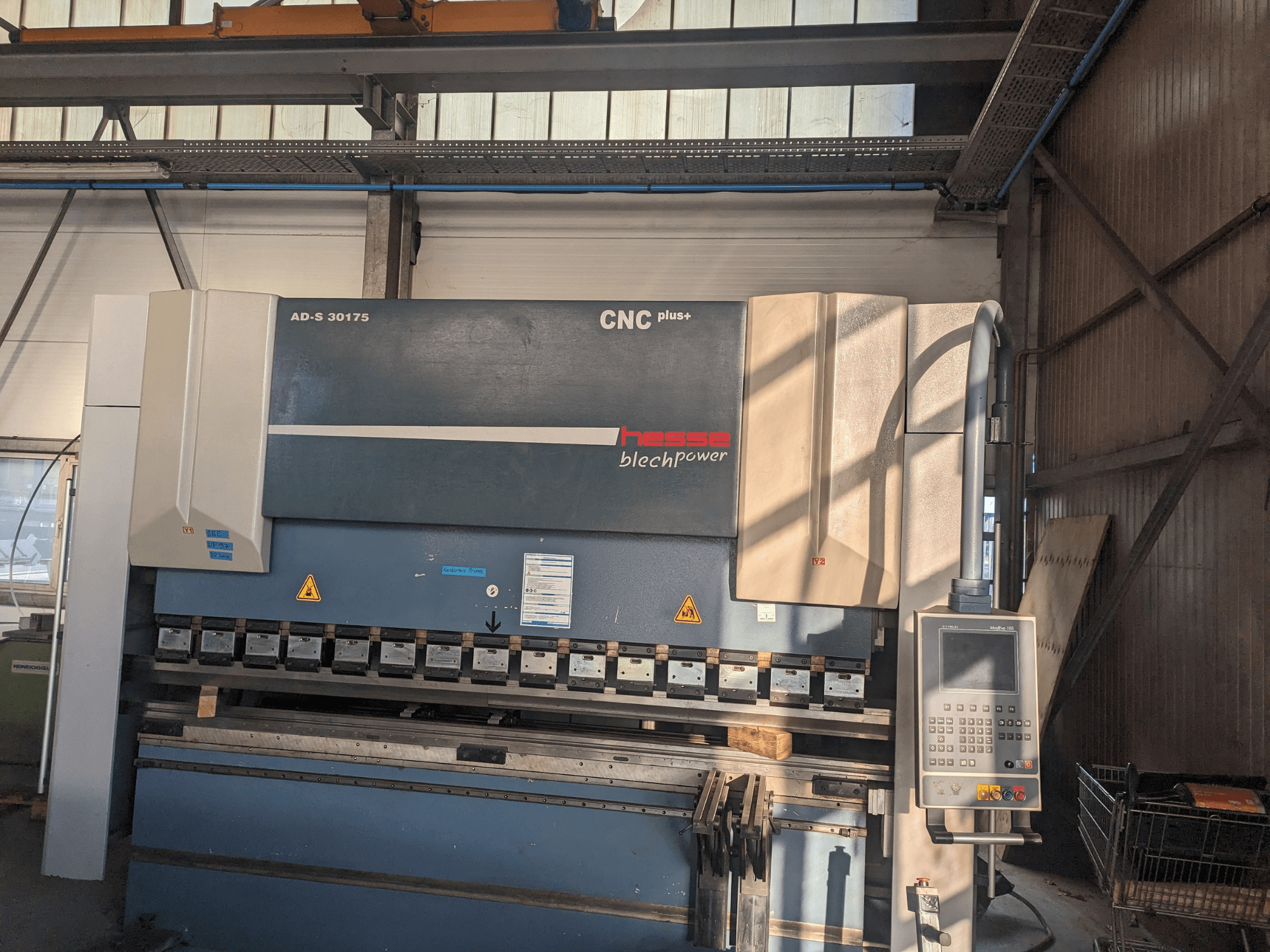Hesse AD-S 30175 CNC-tugevdusmasin, esiplaanil, juhtpaneel ja tööriistad, seadistatud töökojakeskkonnas.