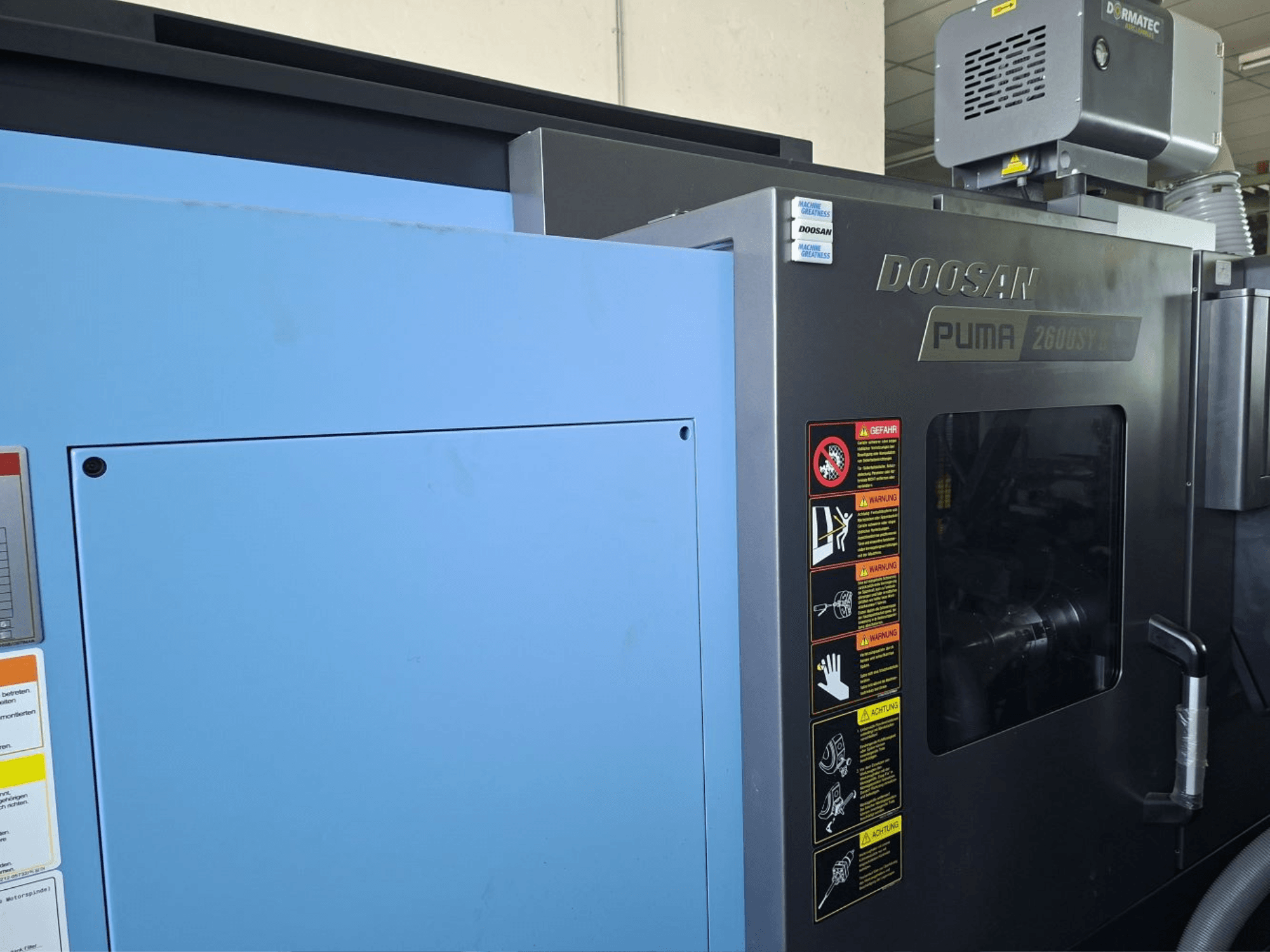 DOOSAN PUMA 2600 SY II horisontaalne treipingi, esiplaanil, ohutusmärgised ja sinised paneelid.