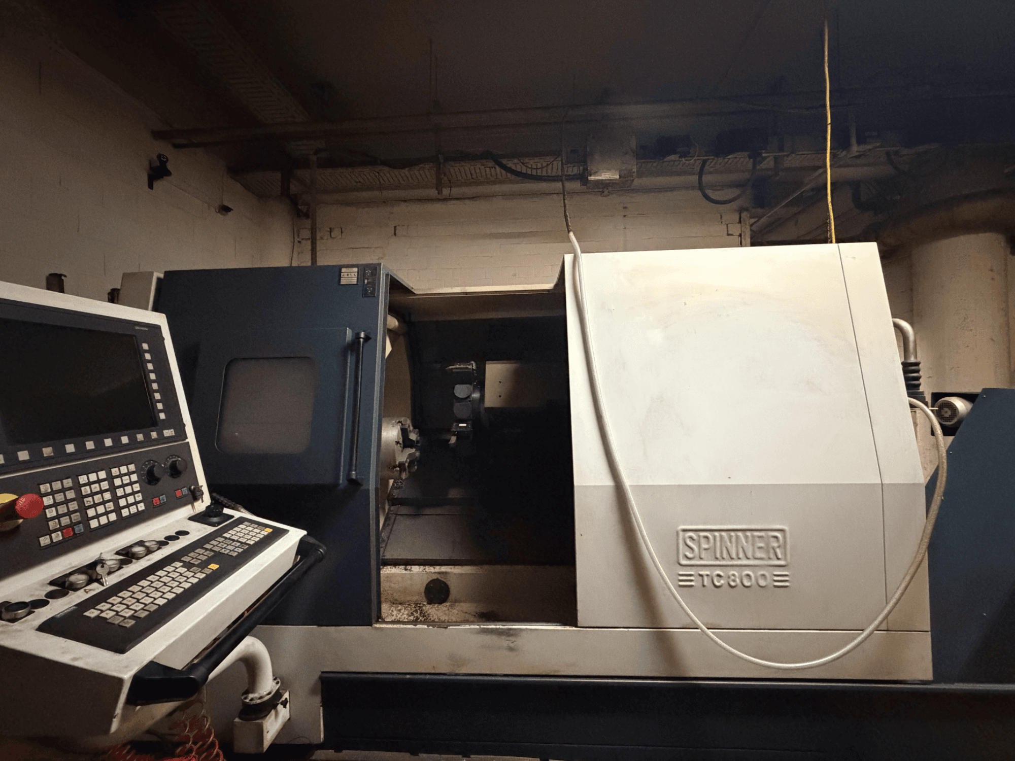 Horisontaalne treipink SPINNER TC800, esivaade, juhtpaneel nähtav ja masina sisemus veidi avatud.