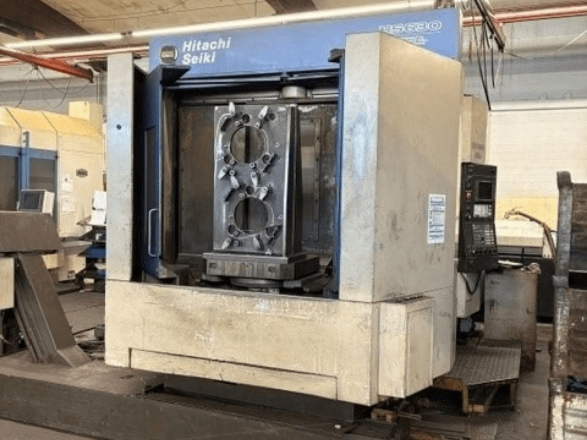 Hitachi Seiki HS630 horisontaalne töötlemiskeskus, esivaade, millel on näha töödeldav detail ja juhtpaneel.