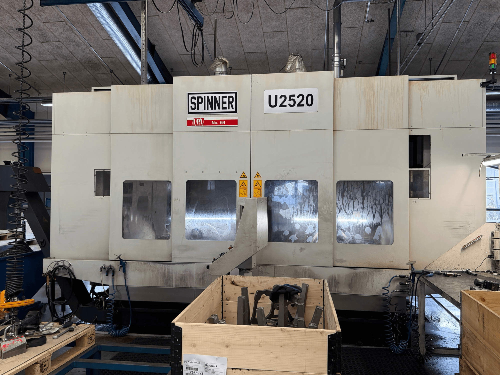 SPINNER U5-2520 vertikaalne töötluskeskus töökojas, esiplaanil, kus on näidatud juhtpaneel ja tööala koos tööriistadega.