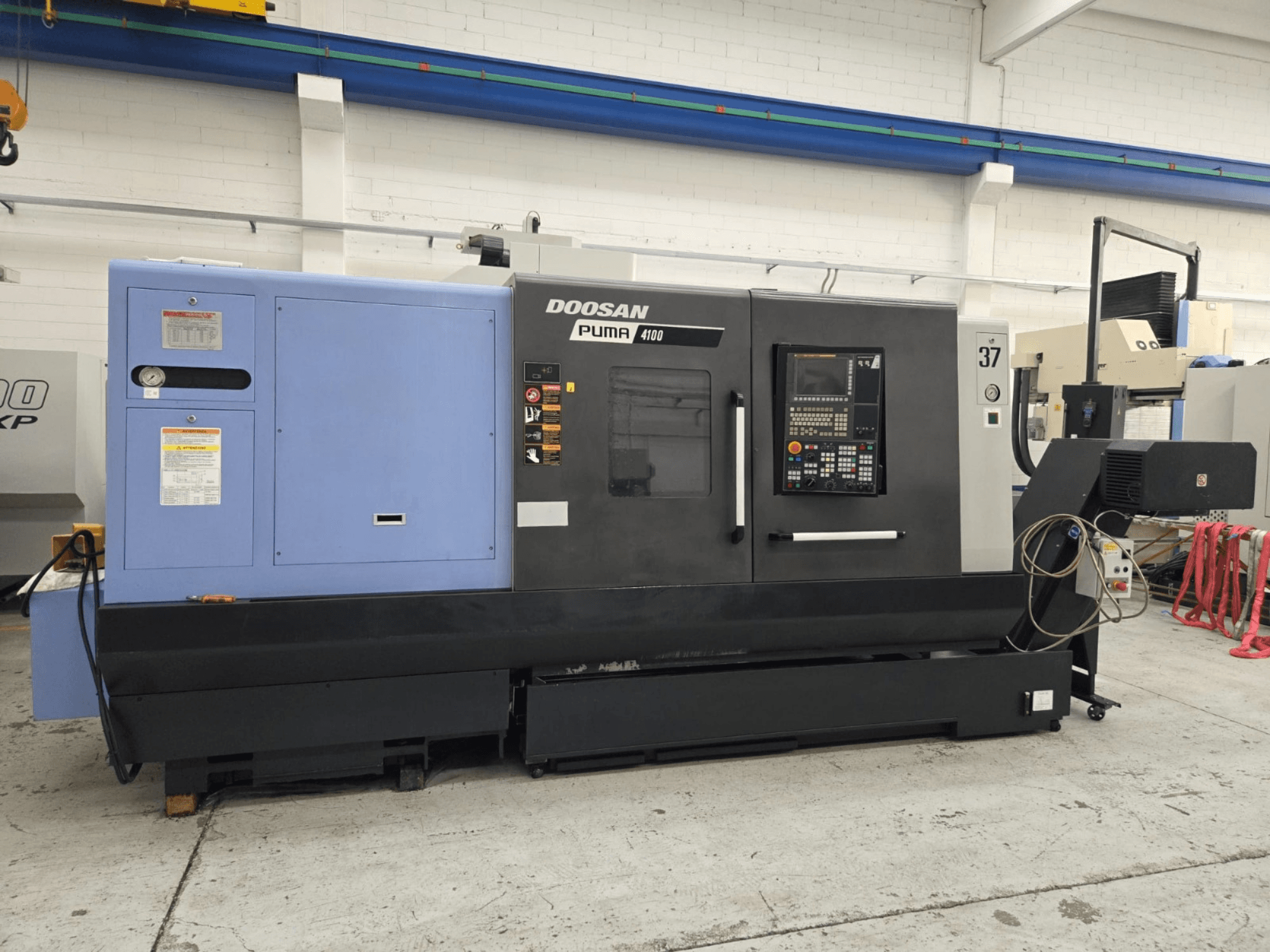Doosan Puma 4100 CNC-teeninduspingi esivaade; juhtpaneel, sinine toiteüksus ja üksikasjalikud sildid tööjuhendamiseks.