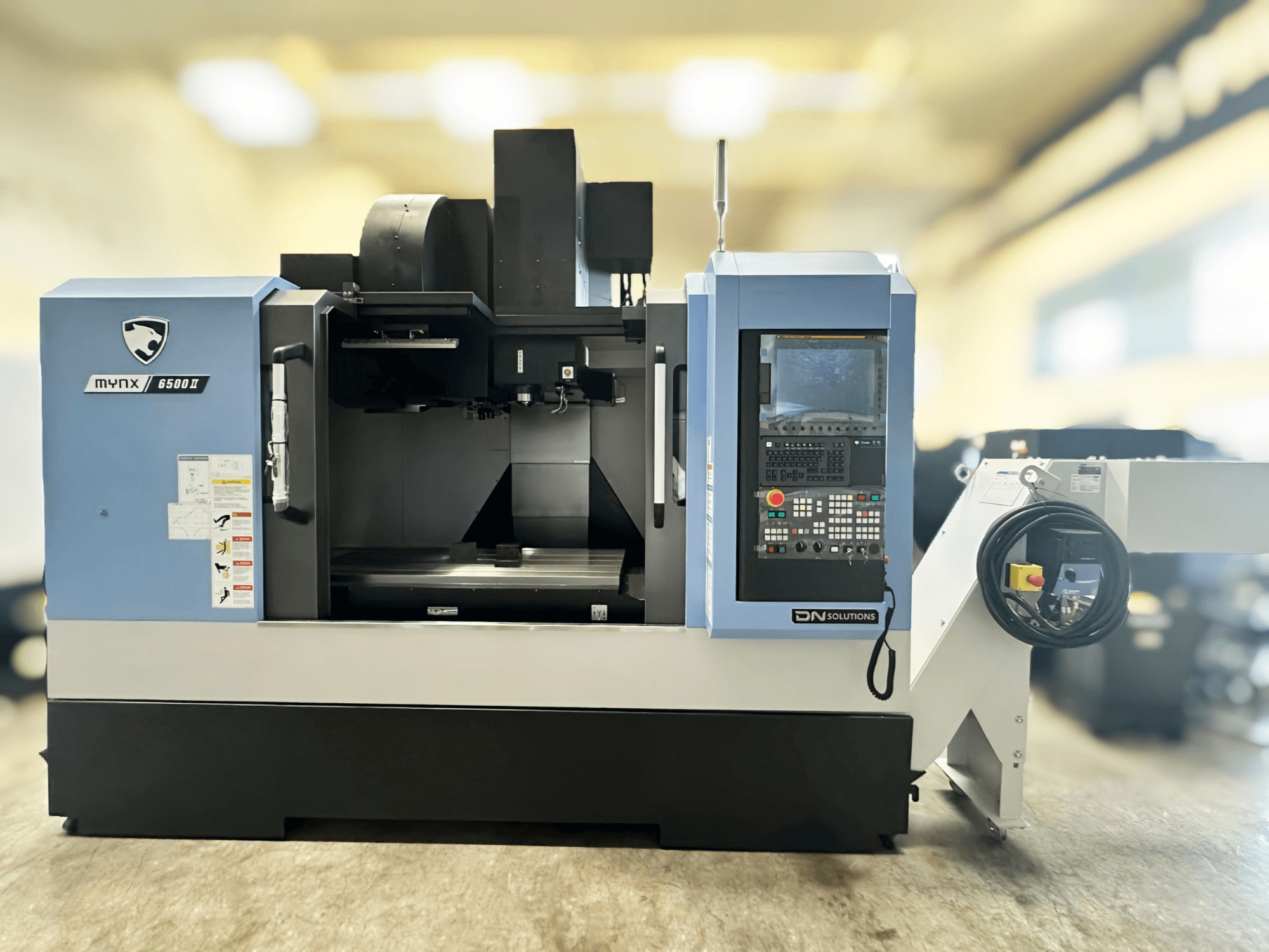 DN SOLUTIONS MYNX 6500 II vertikaalne töötlemiskeskus eestvaates, millel on juhtpaneel ja kasutajaliides.