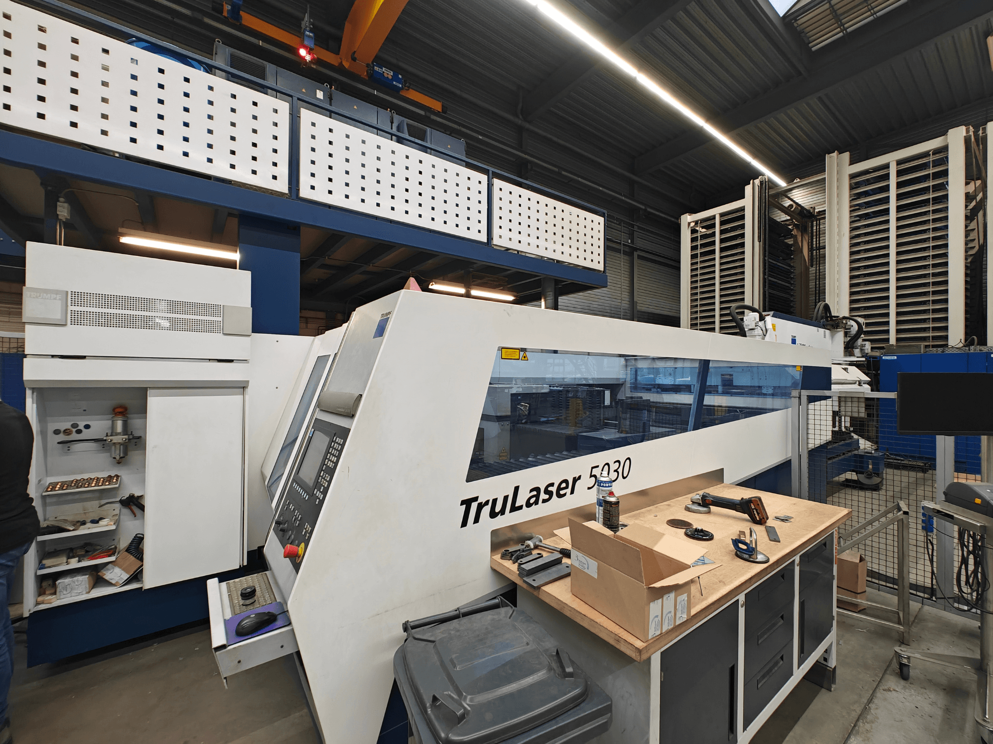 TruLaser 5030 masin töökojas, esivaade, juhtpaneel nähtav, ümberringi tööriistad ja seadmed.