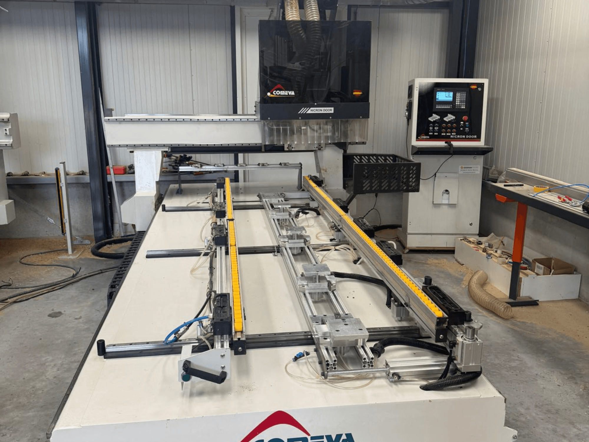 CNC-puidutöötluskeskus COMEVA MEX V 2100x3260 vaade eest, millel on töökoht, juhtpaneel ja juhikud.