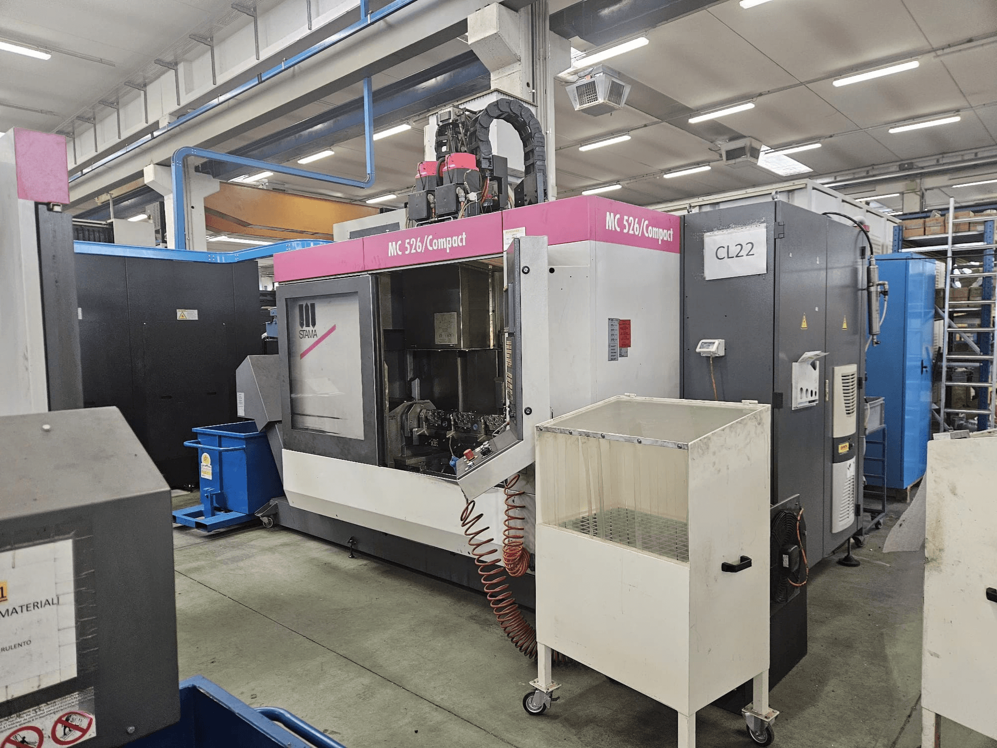 Stama kompaktne CNC-tööpink MC 526, külgvaade, kus on näidatud juhtpaneel, jahutusvedeliku paak ja kõrvalolevad masinad.