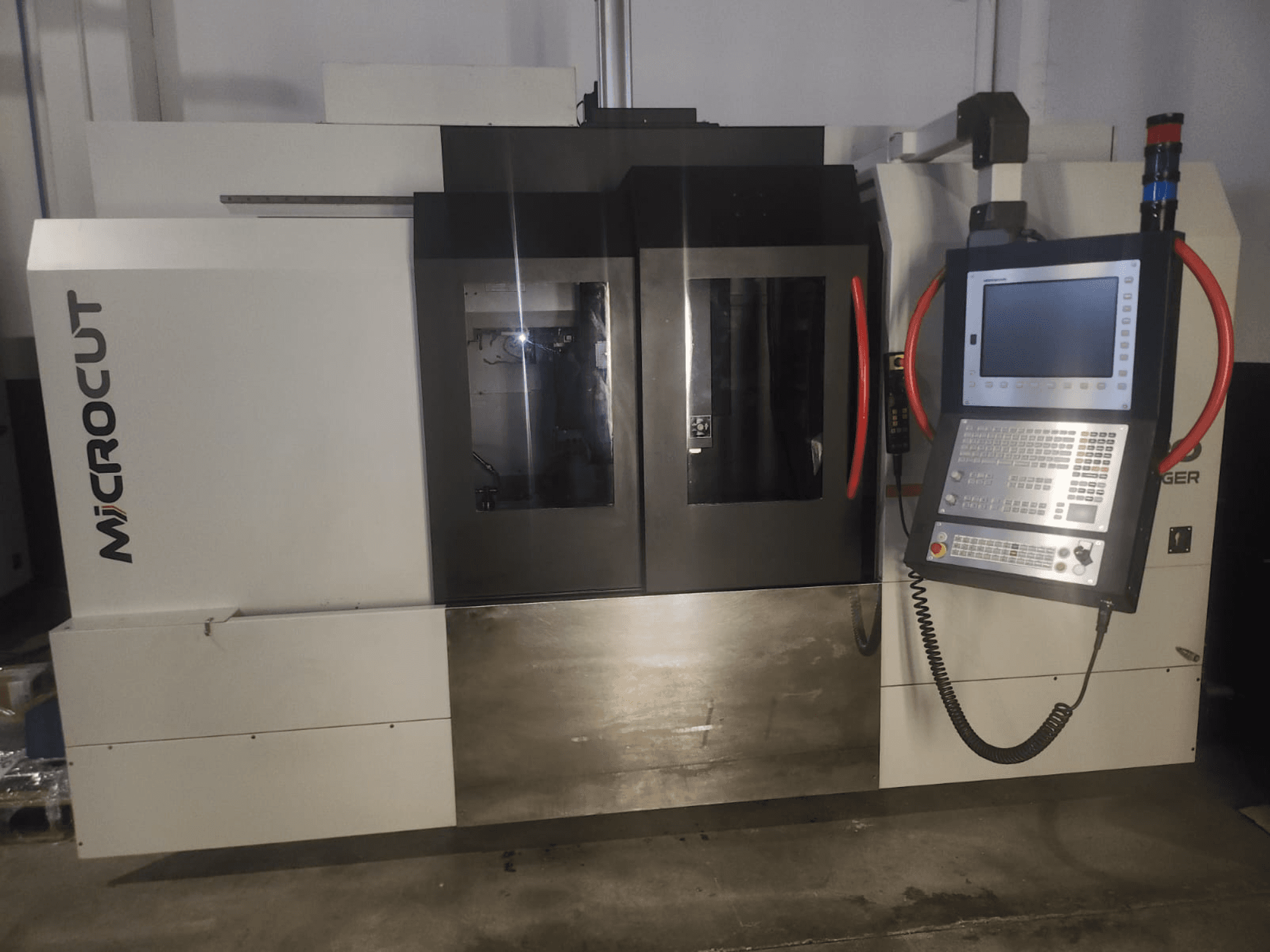 Microcut CNC-tööpink ees; juhtpaneel, kaks akent, tööstuslik disain ja metallist viimistlus.