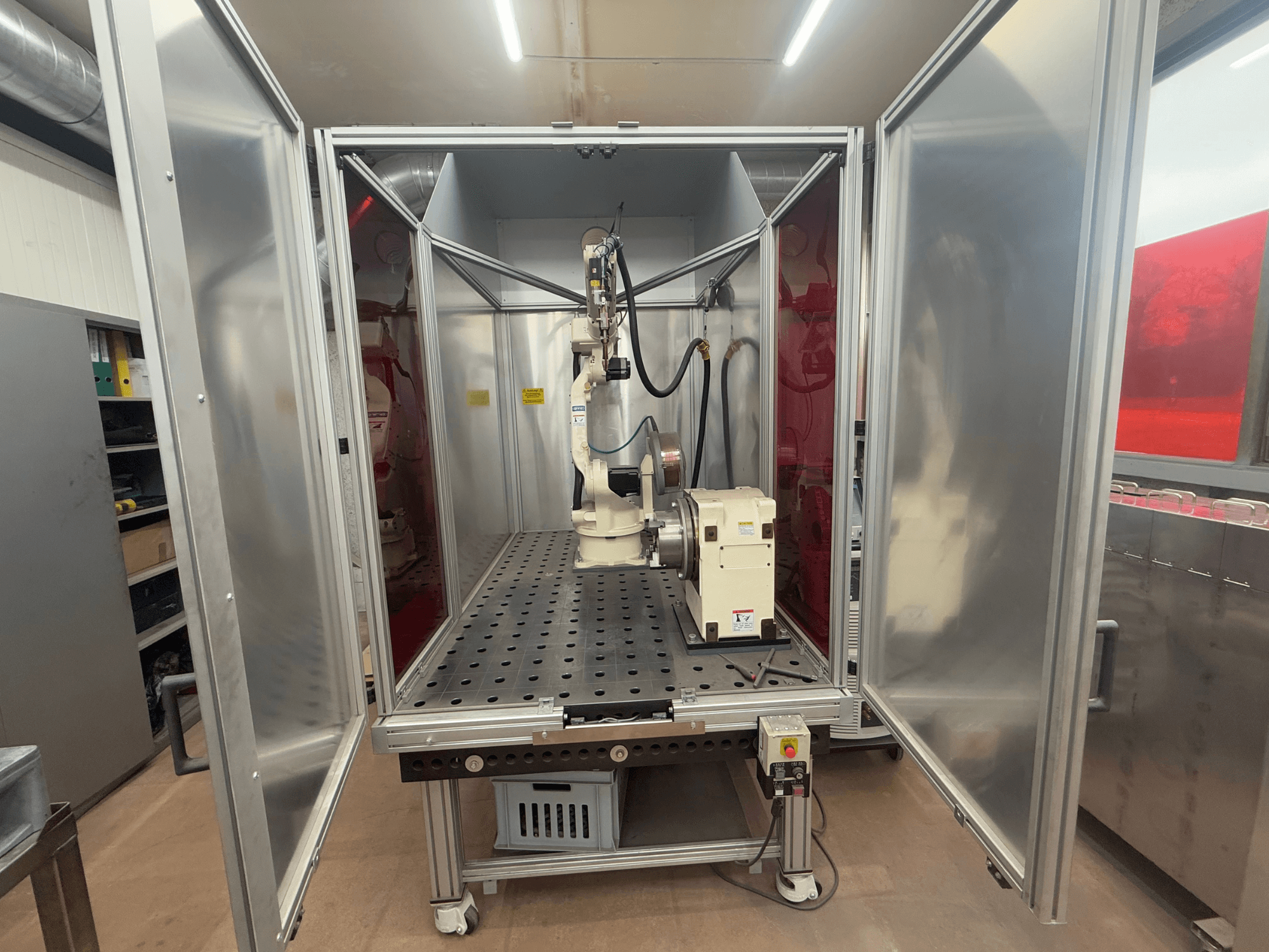 Keevitusrobot OTC Daihen EASY ARC V02.04 metallist korpuses, vaadatuna eestpoolt, näidates selle liigendkäsi ja juhtpaneel.