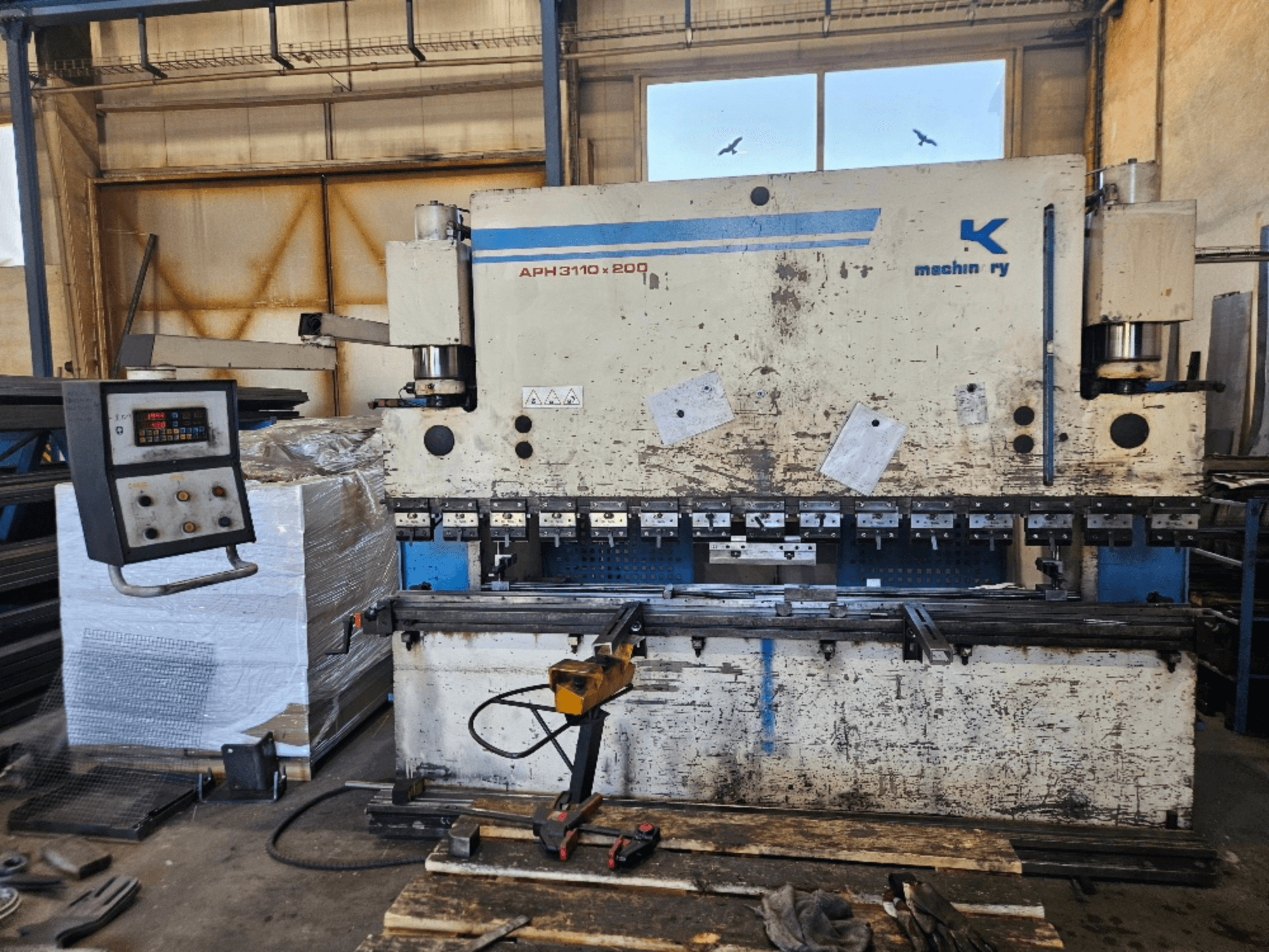 Baykal APH 3110x200 presspink töökojas, esivaade, juhtpaneel, metallplaadid ja tööriistad nähtavad.