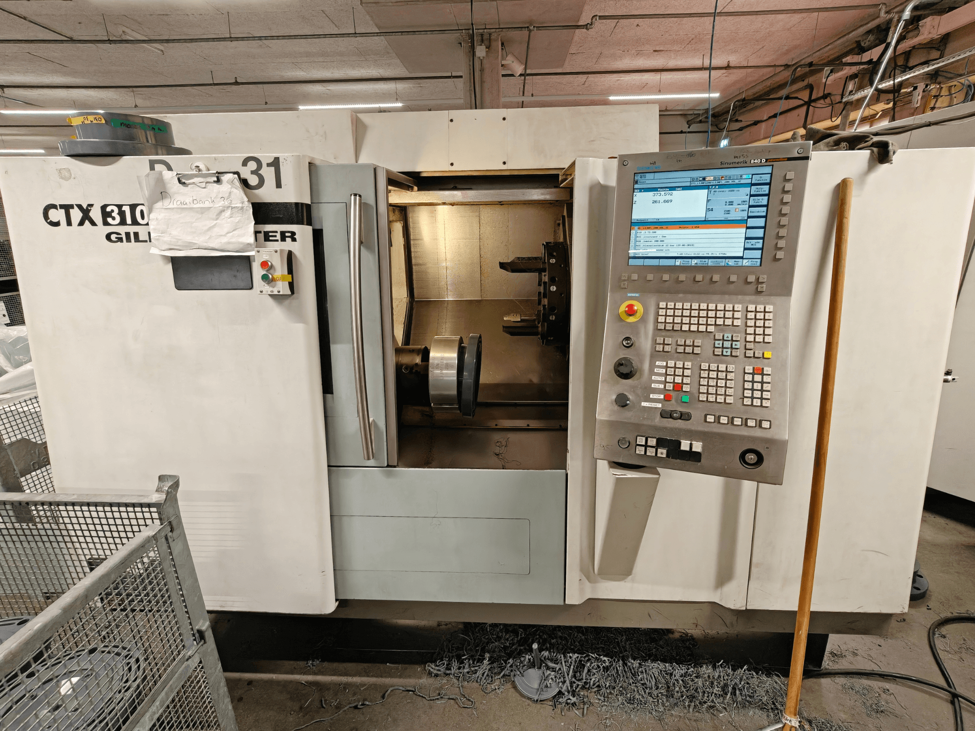 Gildemeister CTX 310 horisontaalne treipink, esikülg koos juhtpaneeliga, kus on näidatud tööriistad ja tööruum.