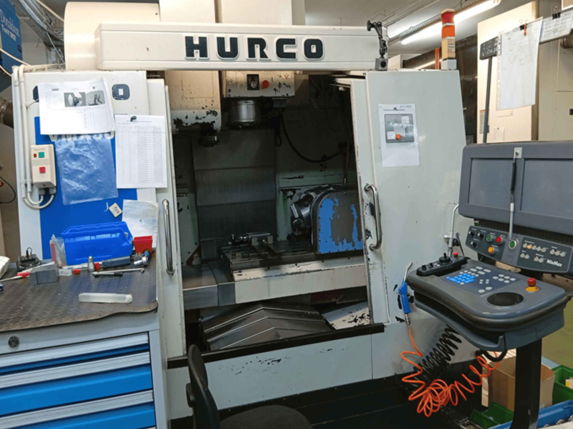 Hurco VMX 30T vertikaalne töötluskeskus, esiplaan, kus on näidatud juhtpaneel, tööruum ja osaliselt avatud uks.