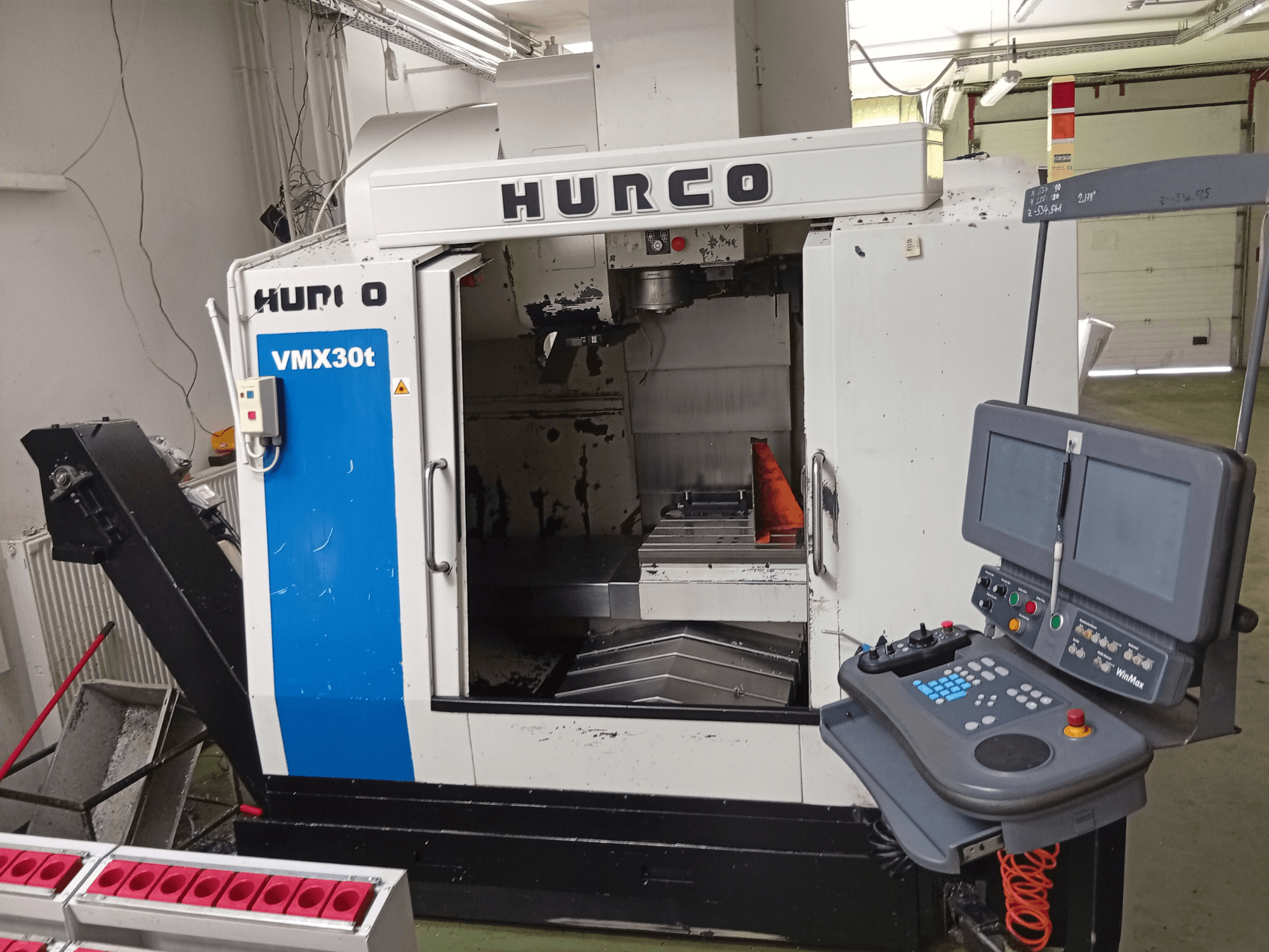 Hurco VMX 30T vertikaalne töötlemiskeskus, vaade eest, millel on näha juhtpaneel ja spindli piirkond koos nähtava tööpinnaga.