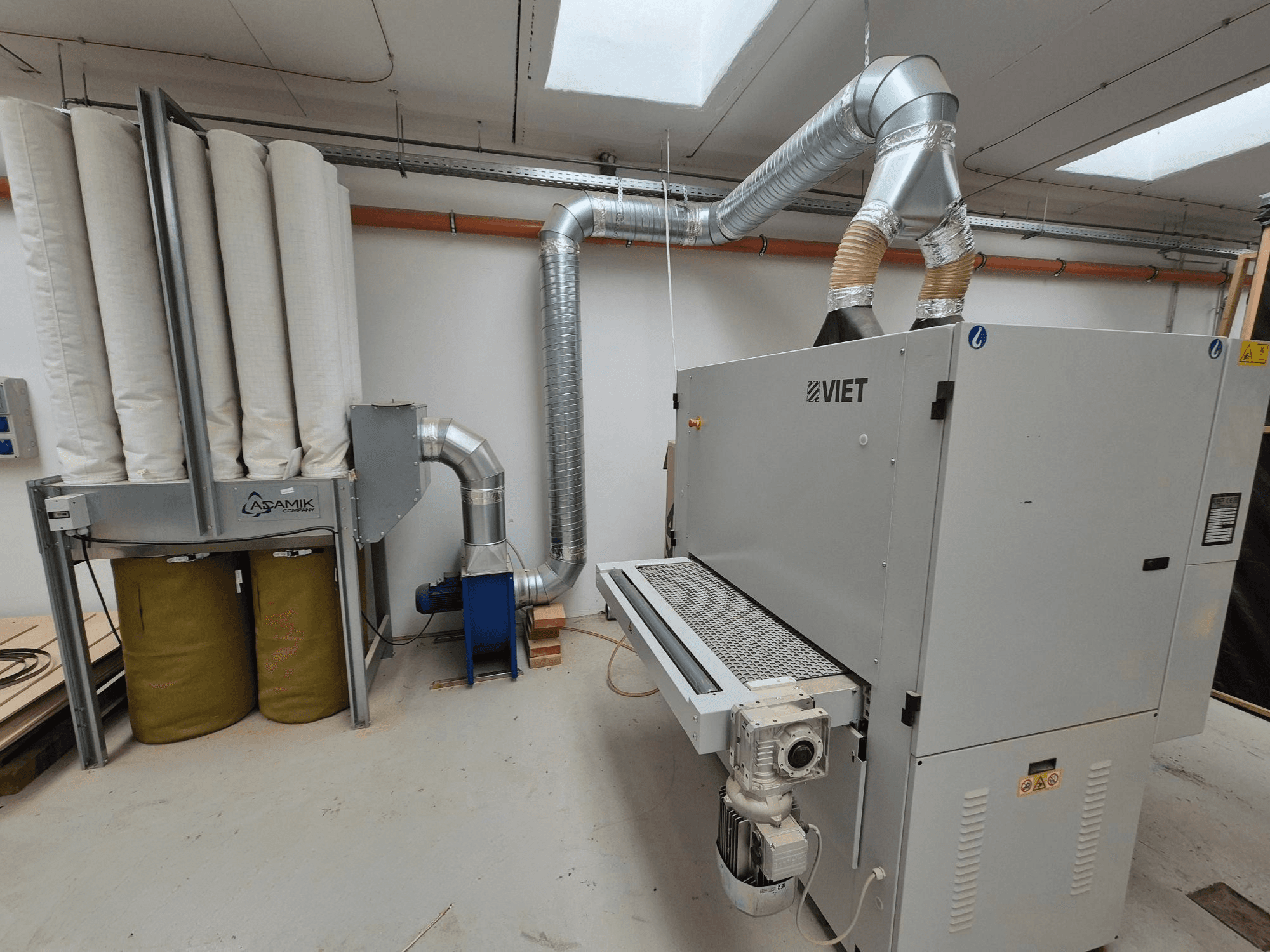 Silindriliste filtrite ja hõbedase väljatõmbega Viet tolmueemaldussüsteem, esiplaanilt vaadatuna töökojas.