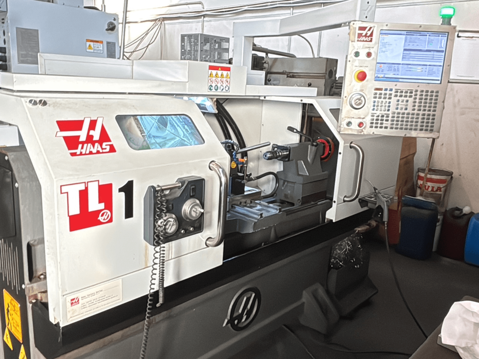 Haas TL-1 CNC-treipingi esivaade, millel on juhtpaneel koos ekraaniga, tööriistahoidik ja ohutussildid.