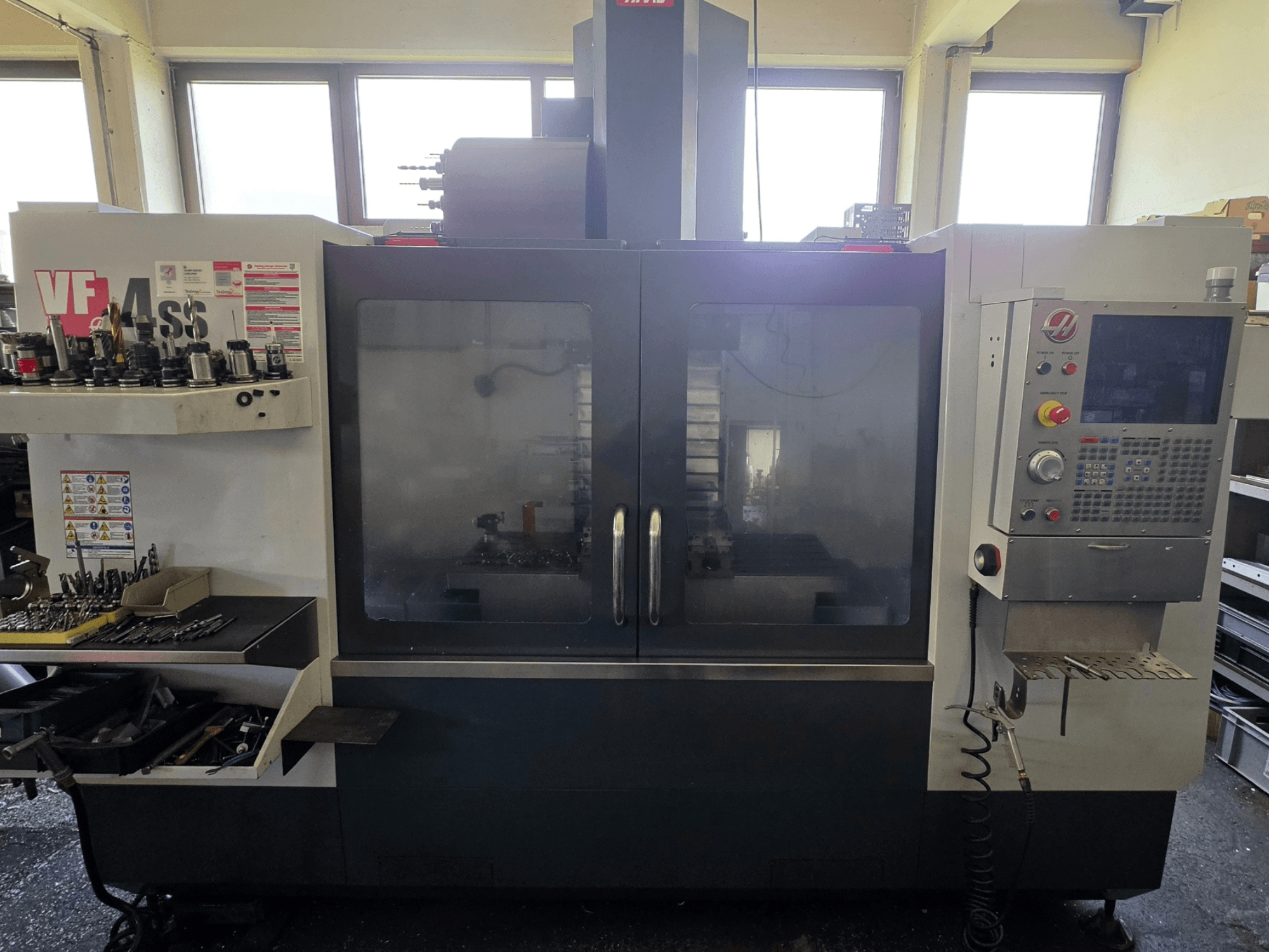 HAAS VF 34SS vertikaalne töötlemiskeskuse esivaade, kus on näha juhtpaneel ja tööriistade hoiuruum.