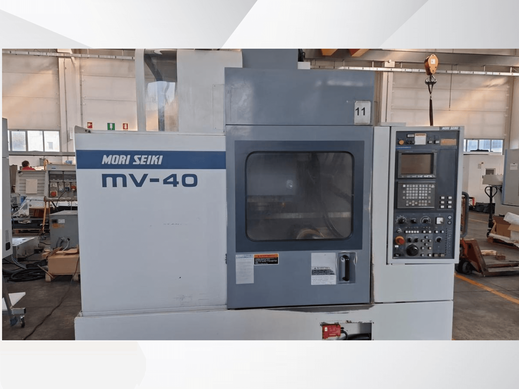 MORI SEIKI MV-40 vertikaalne töötluskeskus, esiplaan, kus on näidatud juhtpaneel ja aken, töökojas.
