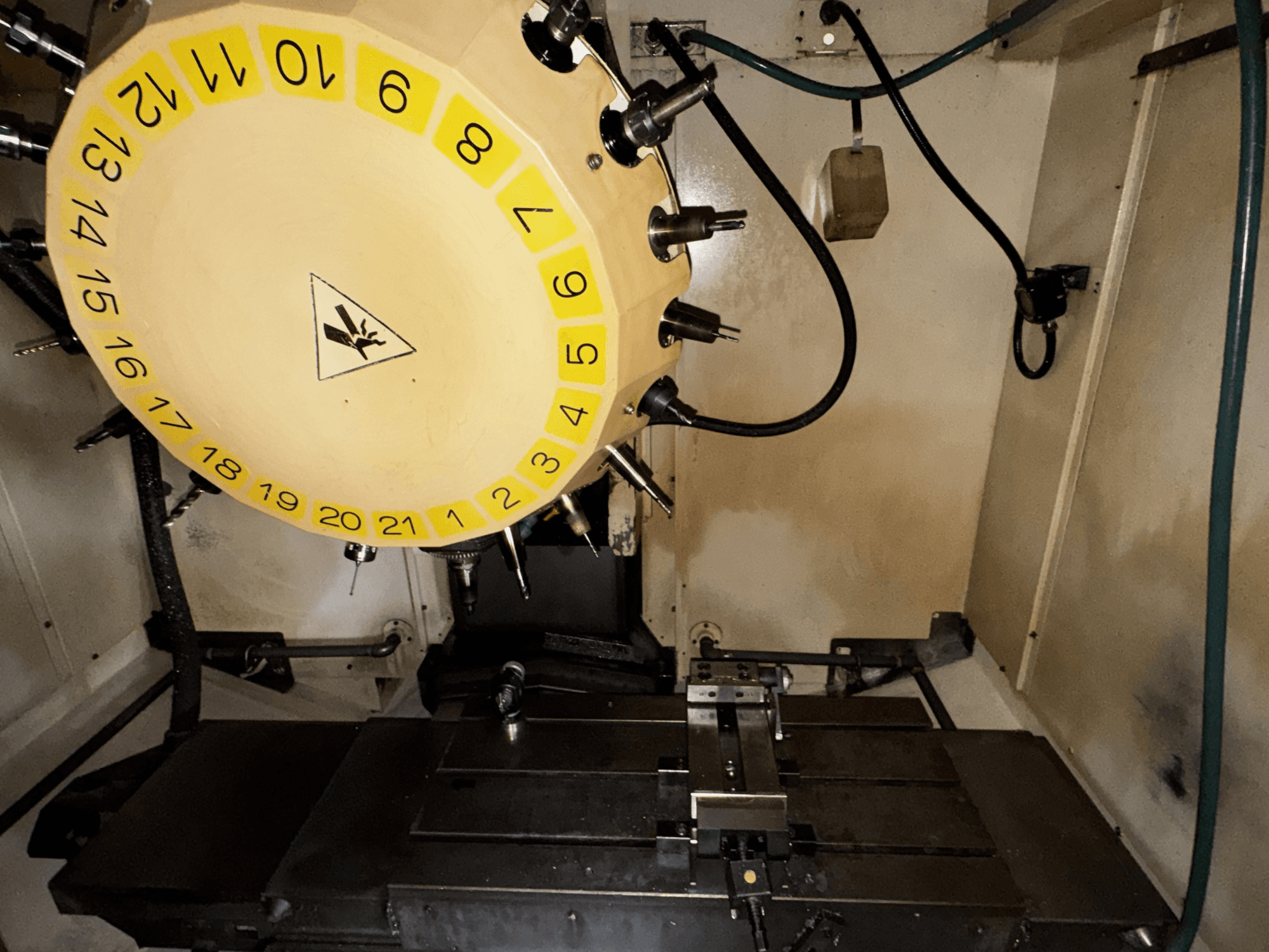 FANUC Robodrill alpha-T21iFL vertikaalne töötlemiskeskuse sisevaade, kus on näha tööriistakarussell ja töötlemislaud.