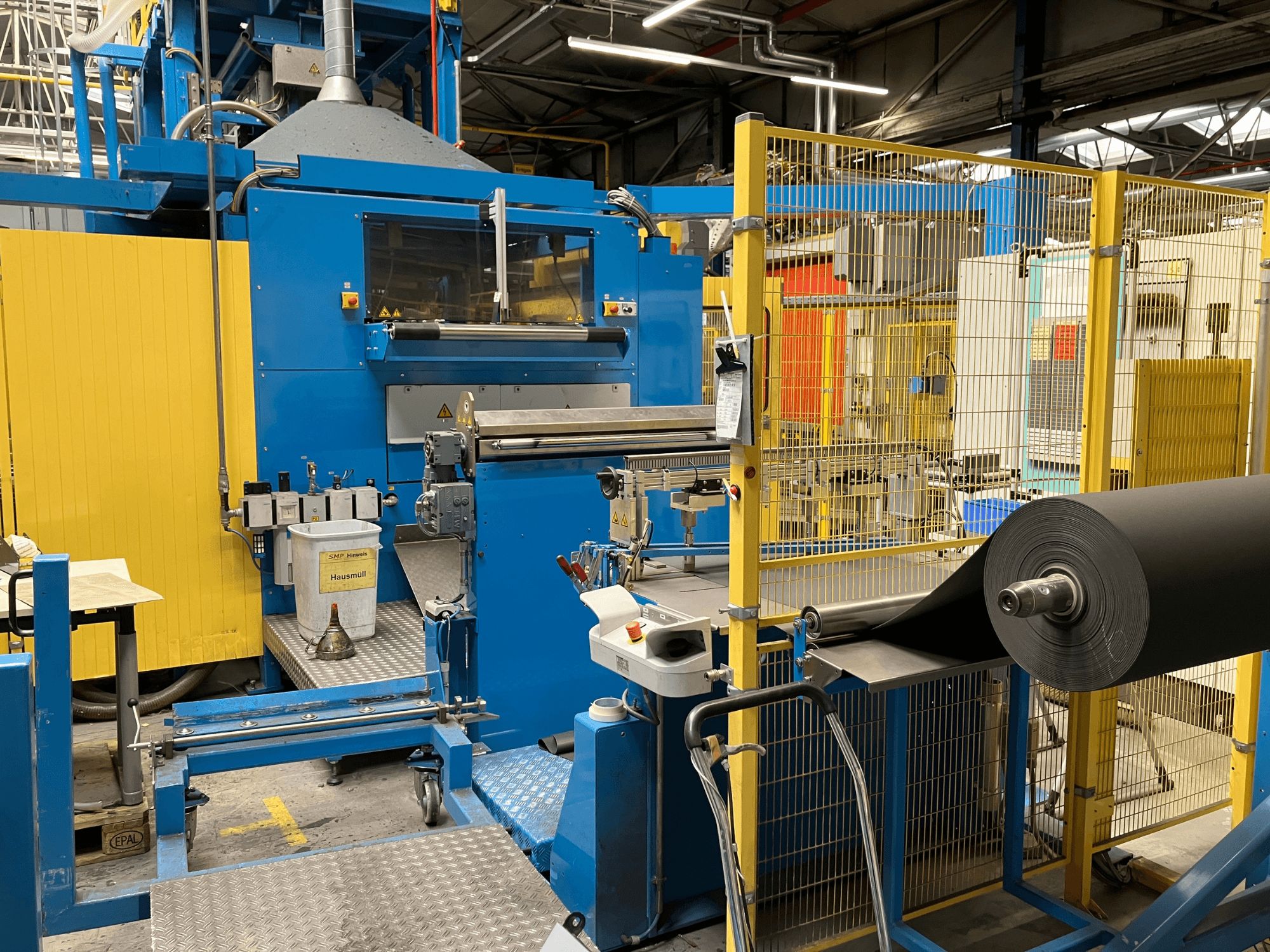 KIEFEL KLS 86/235 plastitöötlemismasin esiplaanilt, must materjalirull ja juhtpaneel.