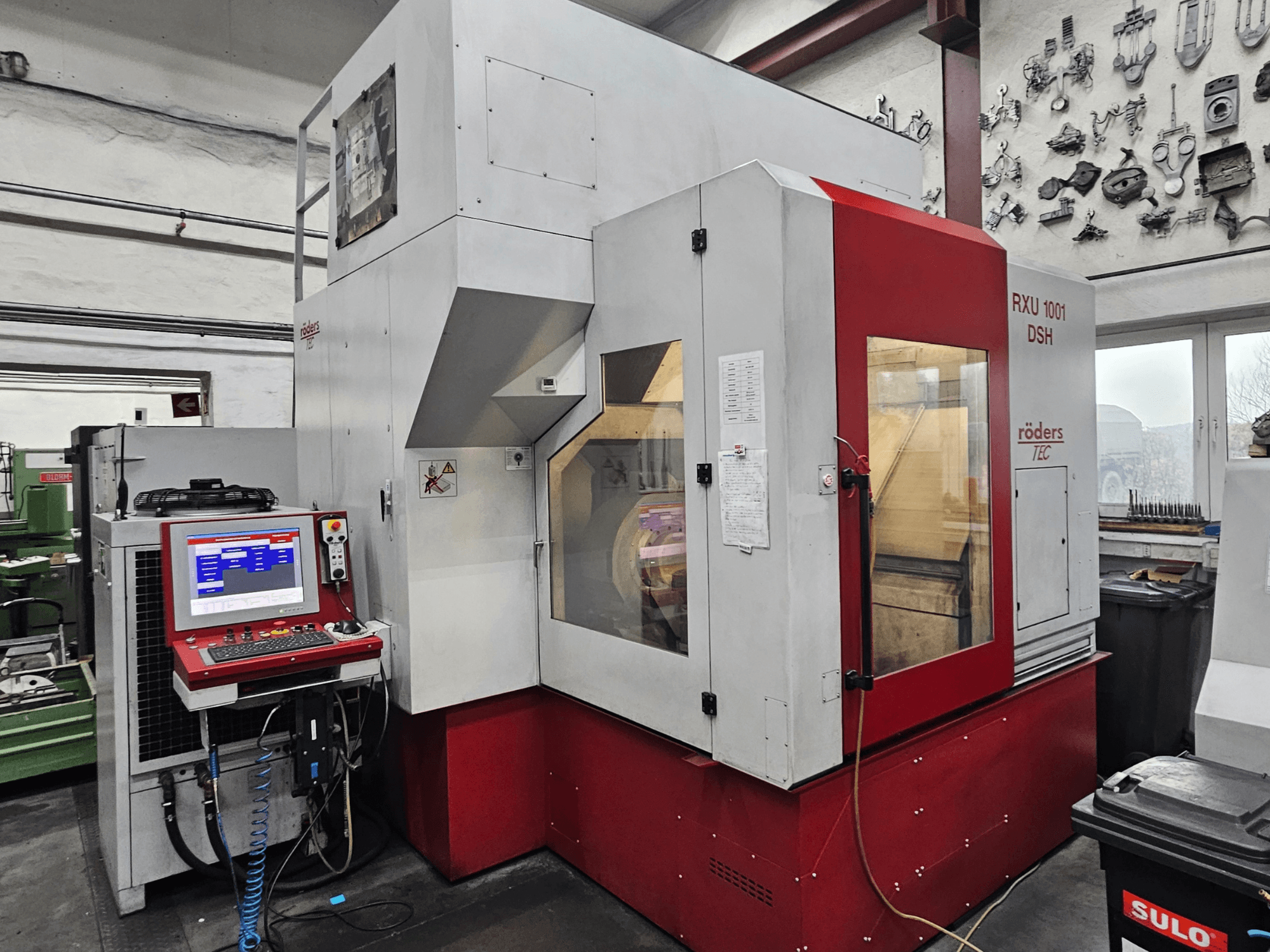 RÖDERS RXU 1001 DSH vertikaalne töötluskeskus, esiplaanil on juhtpaneel ja masina üksikasjad töökojas.