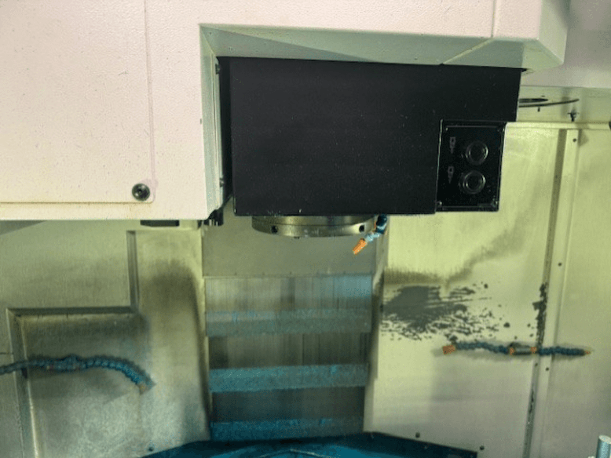 CNC-freespingi juhtpaneeli ja tööriistahoidiku lähivaade, mis näitab kaubamärgi üksikasju, nuppe ja tööpinda.