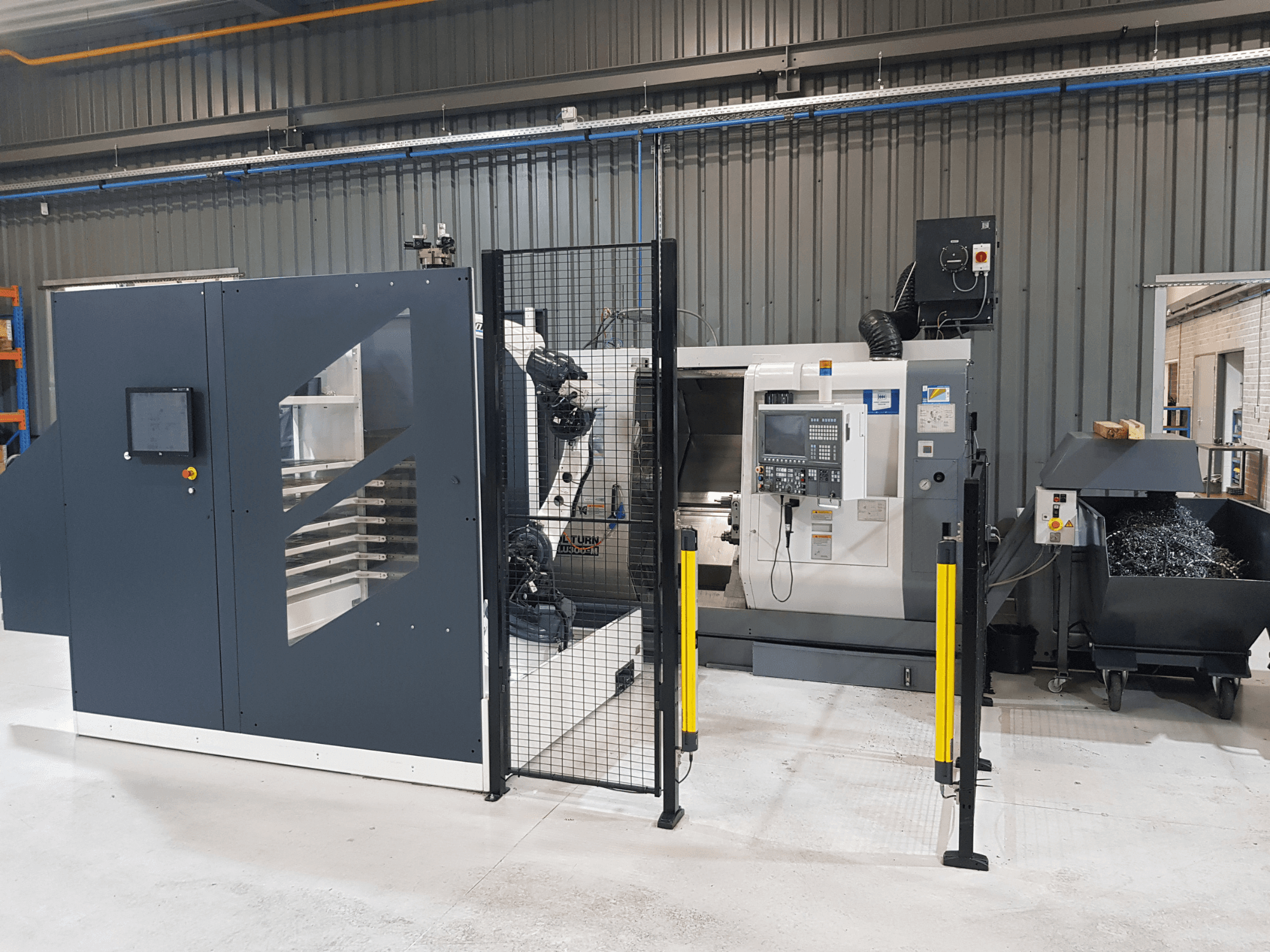 ALTURN automaatne treipink ja CNC-pingi tehase seadistuses; esiplaanil on näha juhtpaneel ja turvapiire.