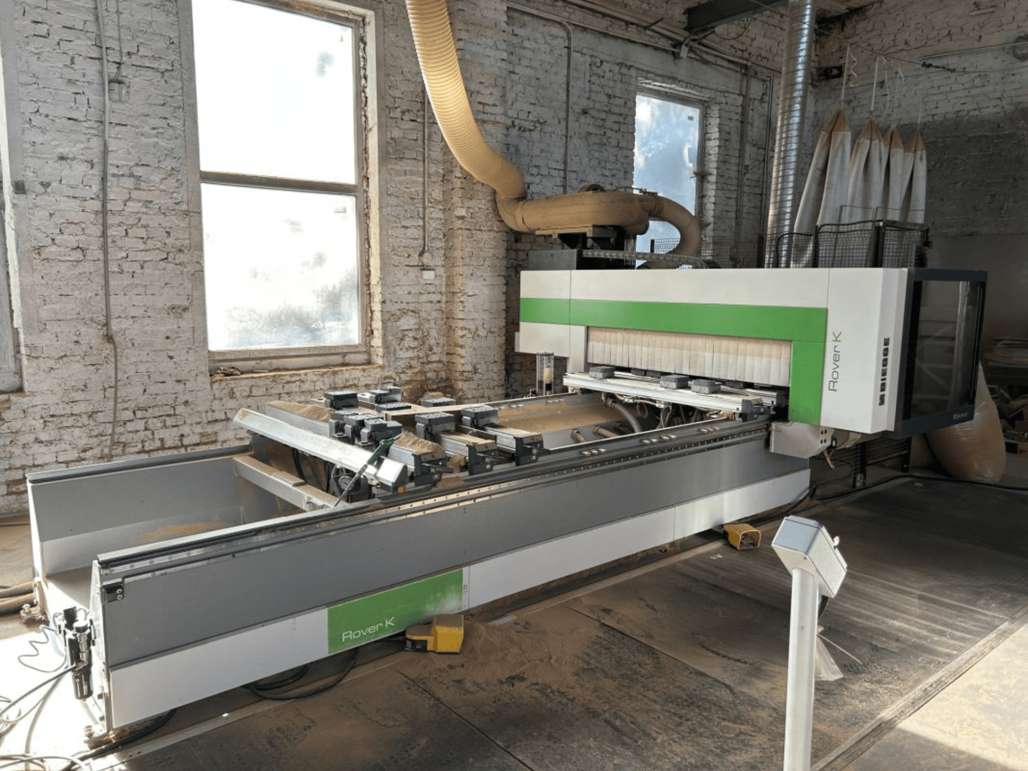 Töökojas asuv CNC-töötlemiskeskus BIESSE Rover K 1532 G, vaadatuna eestpoolt, millel on näha selle lõikeriistad ja tööpind.