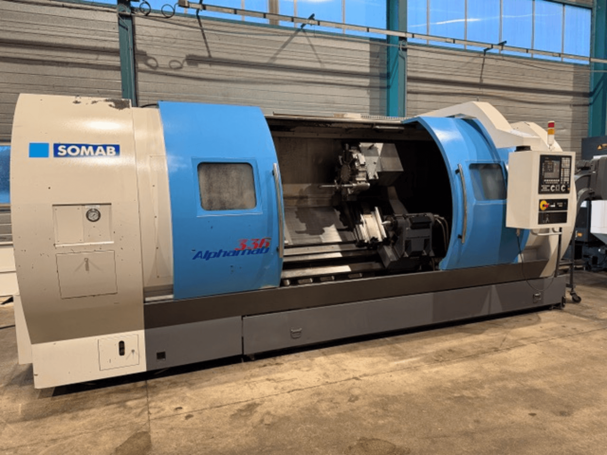 SOMAB Alpha 336 CNC-teeninduspingi esiplaan, sinise ja halli korpusega ning küljel oleva juhtpaneeliga tööks.